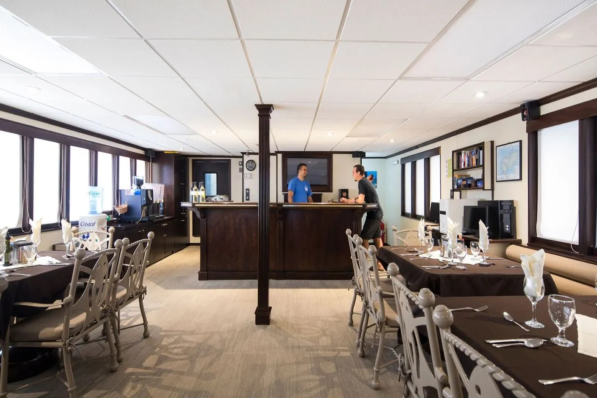 Restaurant of Okeanos Aggressor II with tables laid for dinner