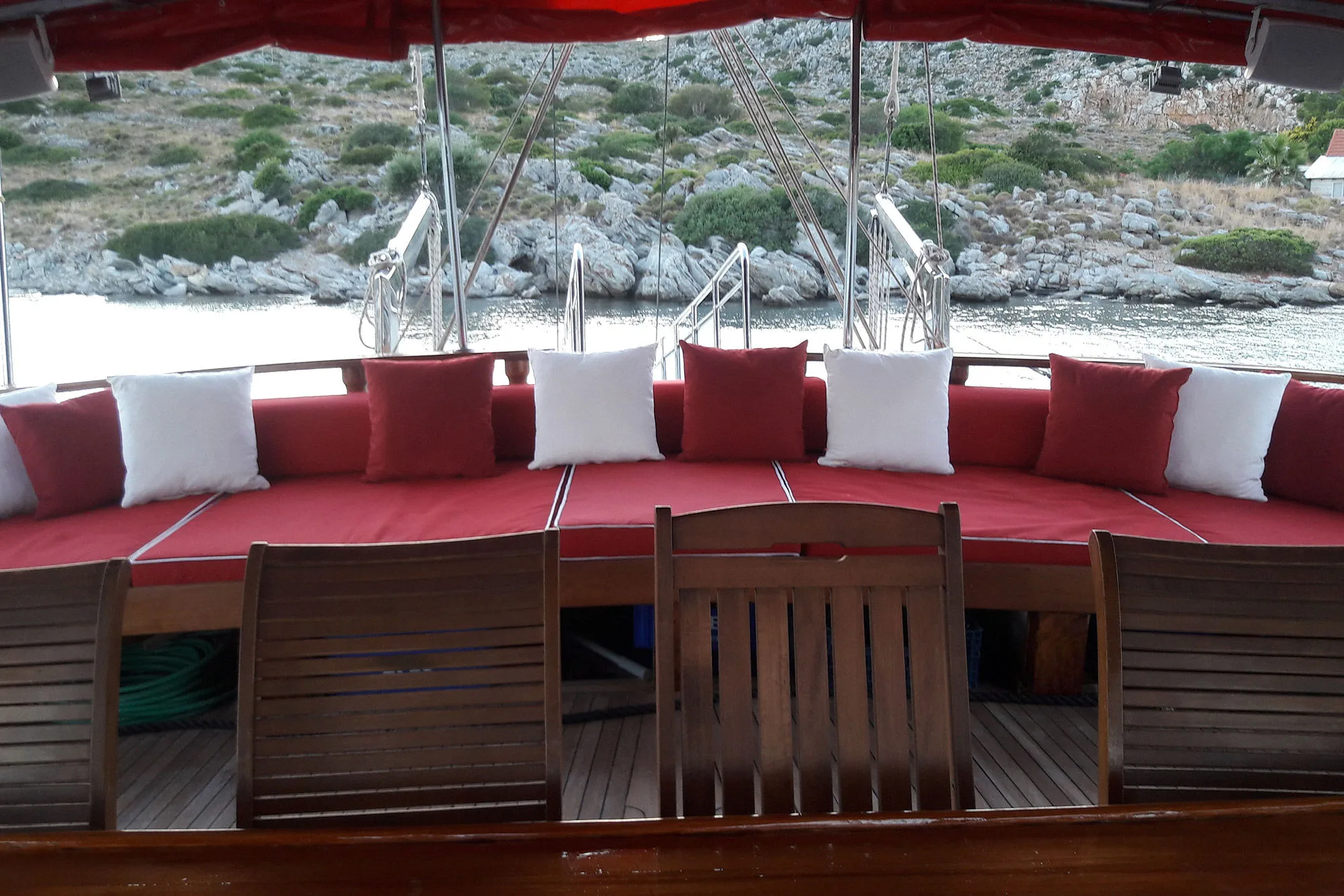 Aft saloon with a curved bench in red and white cushions