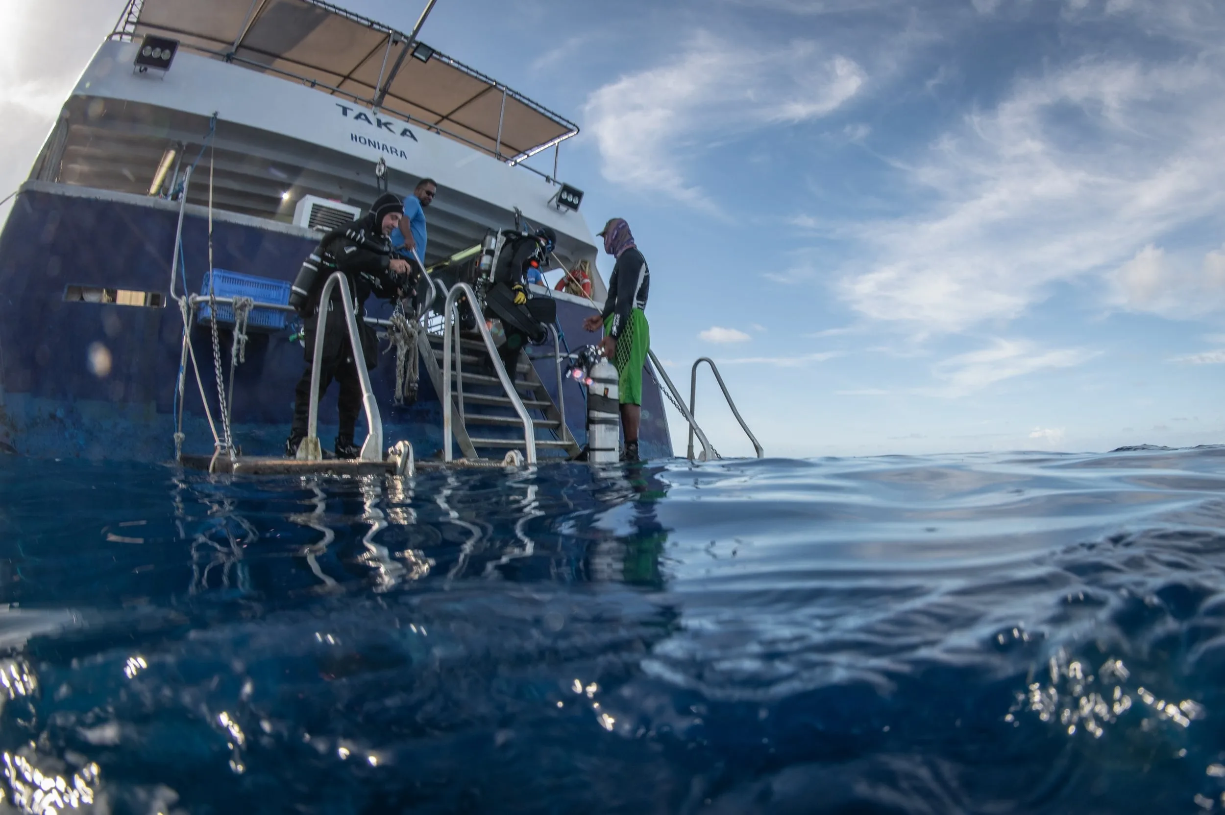 Divers entering the water from the platform of Pacific Master