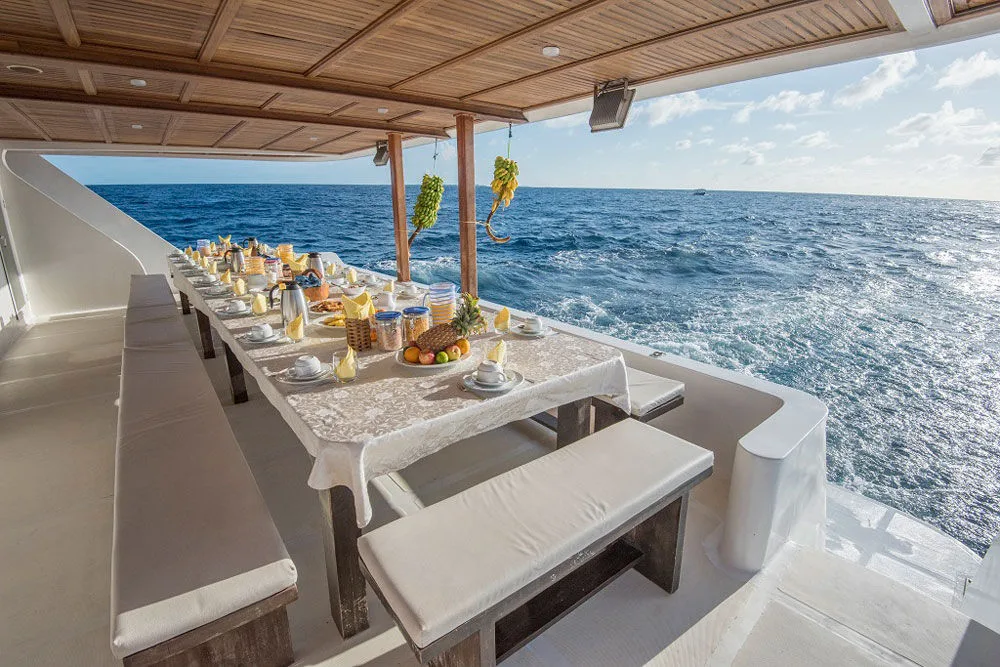 Al fresco dining table on Princess Dhonkamana overlooking the ocean