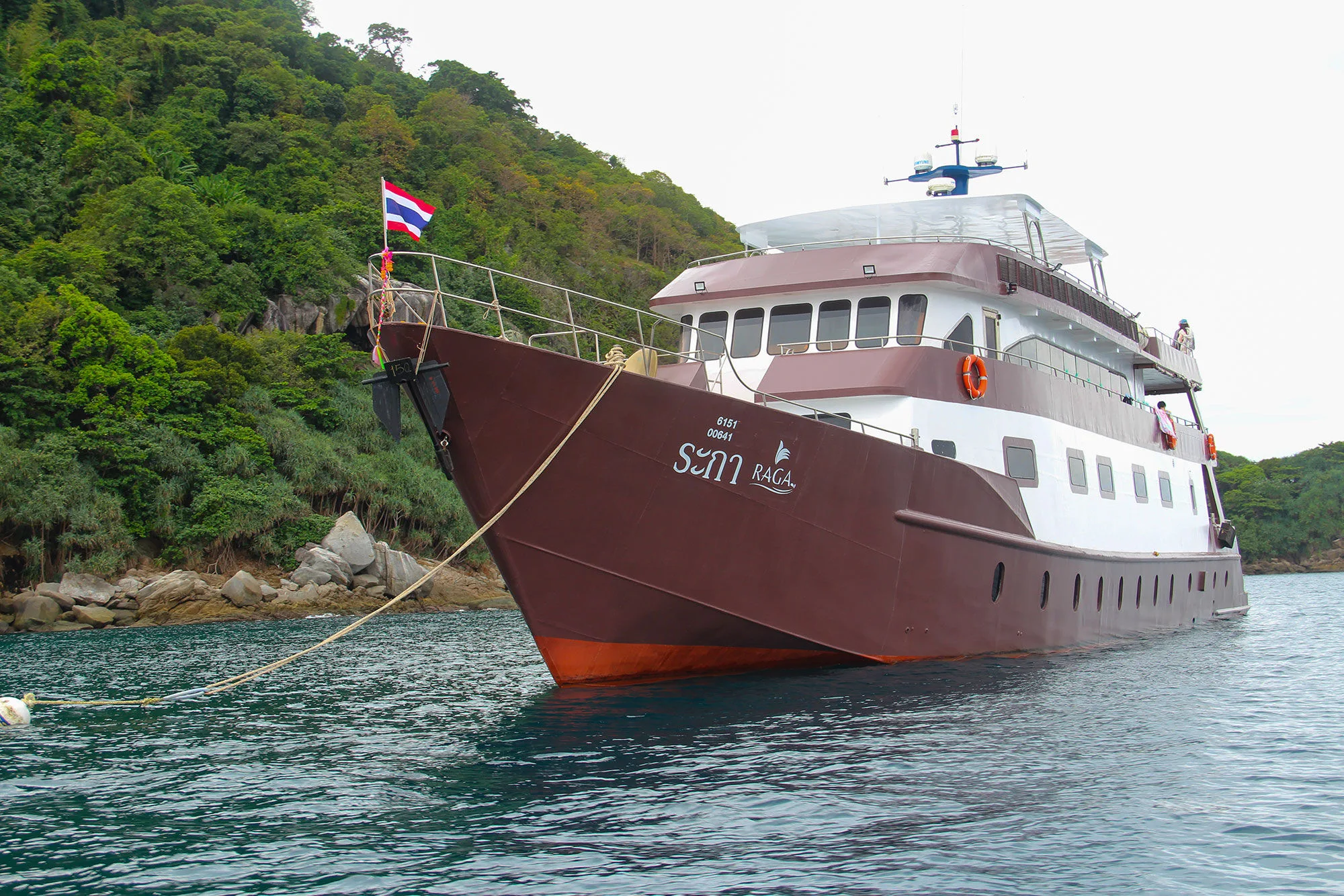 Raga at anchor off a forested island