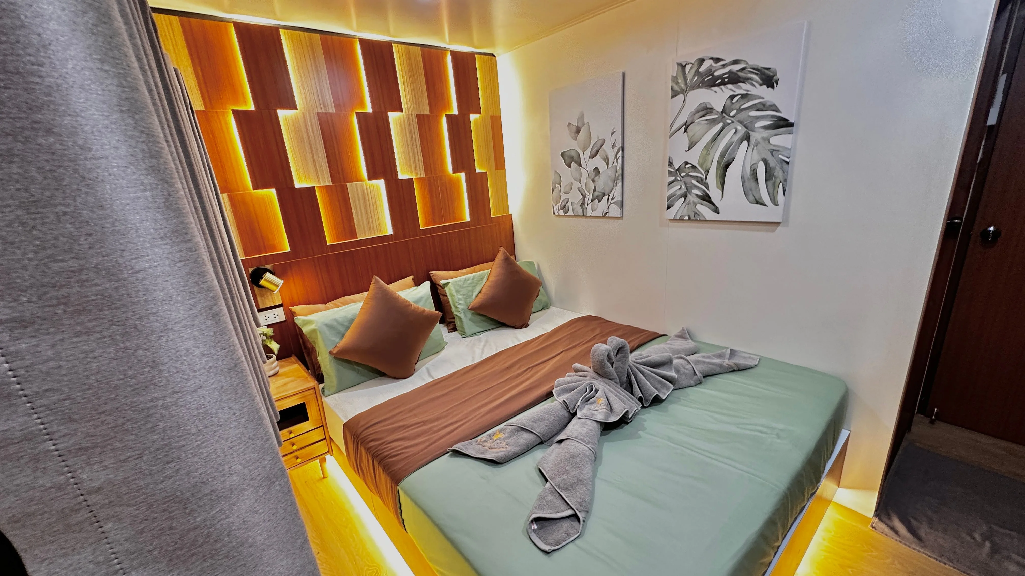 Raga standard cabin with a double bed and a backlit headboard