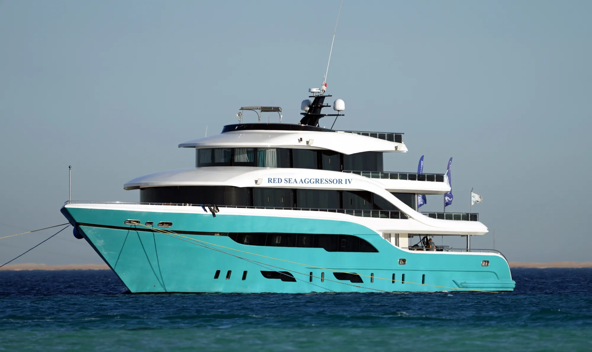 Red Sea Aggressor IV на якоре в Красном море — бирюзовый корпус и белая надстройка в три палубы