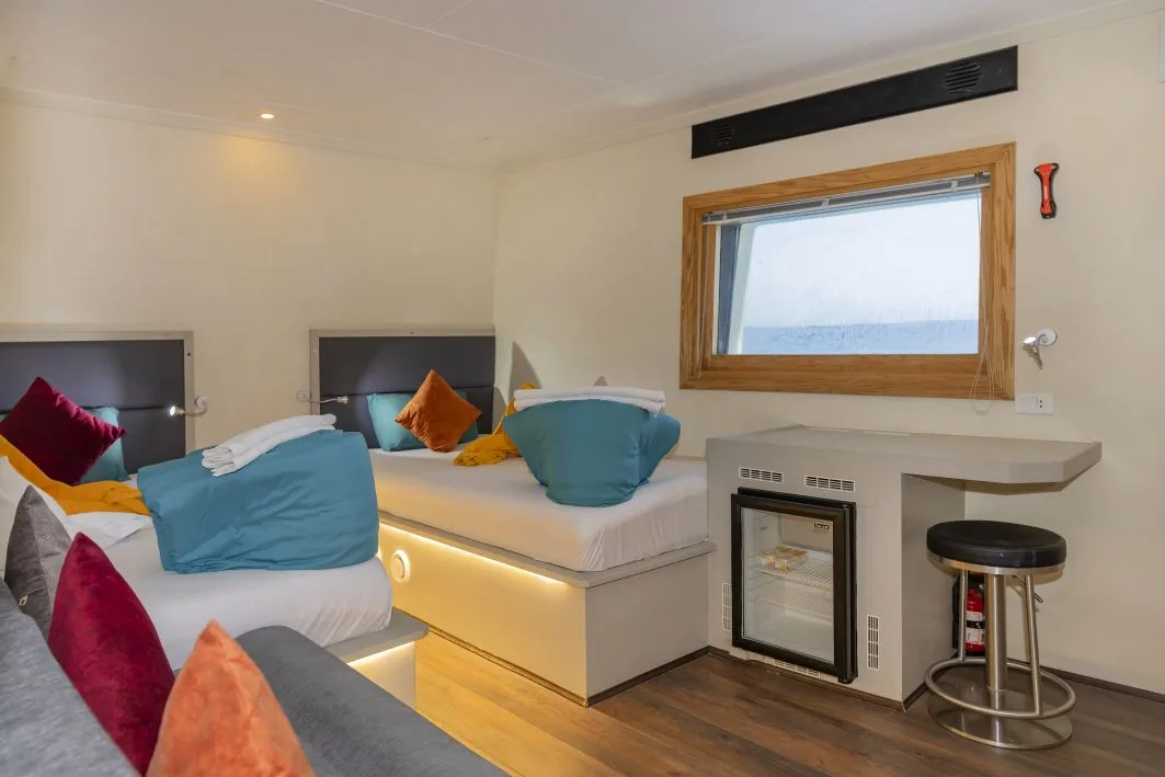 Master Twin cabin with twin beds and a sofa along the bulkhead
