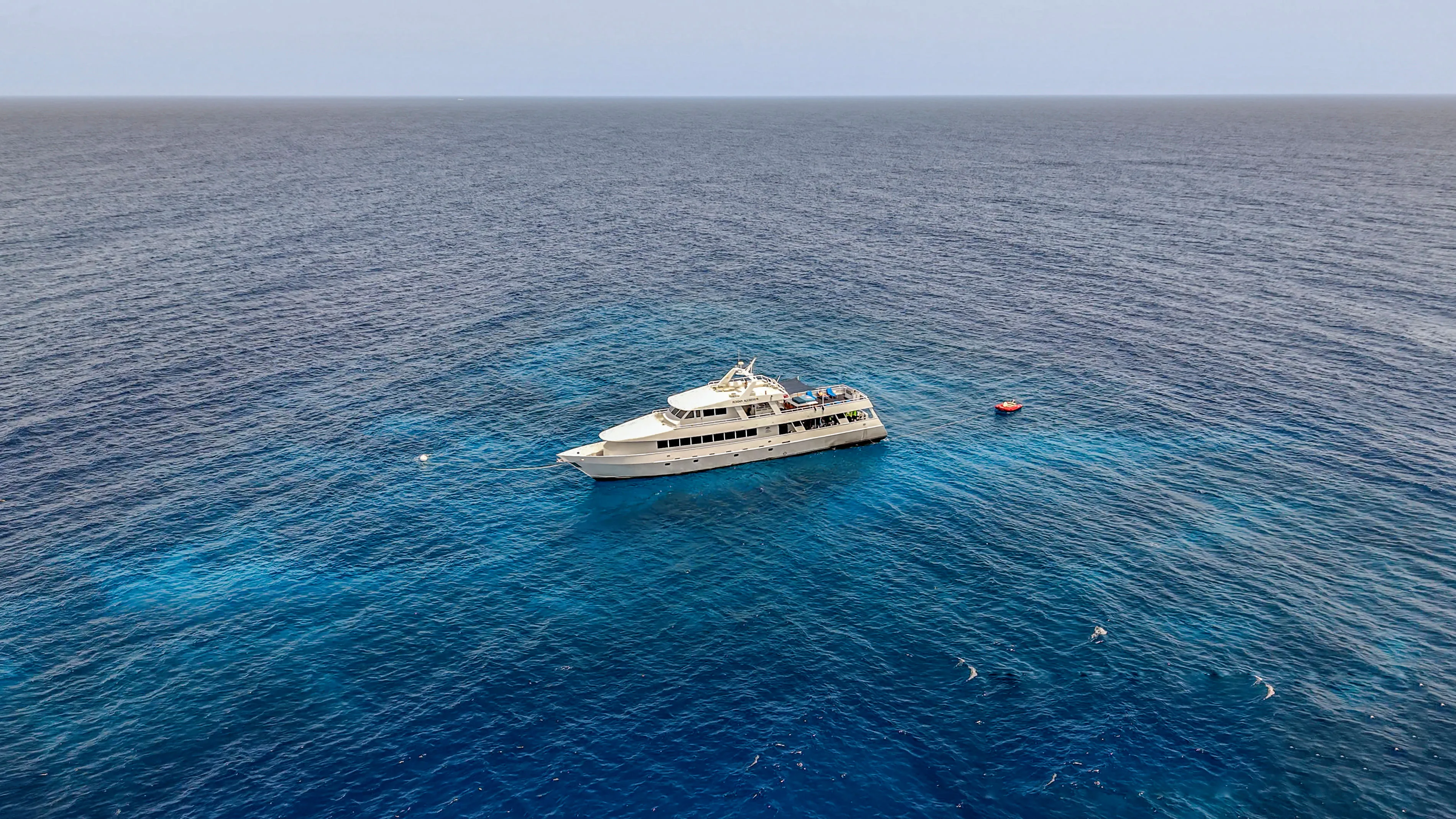 Дайверы у борта Roatan Aggressor над рифом в открытом море