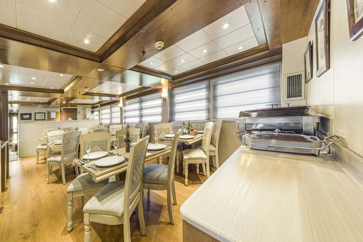 The dining room of Royal Evolution, tables laid for 24