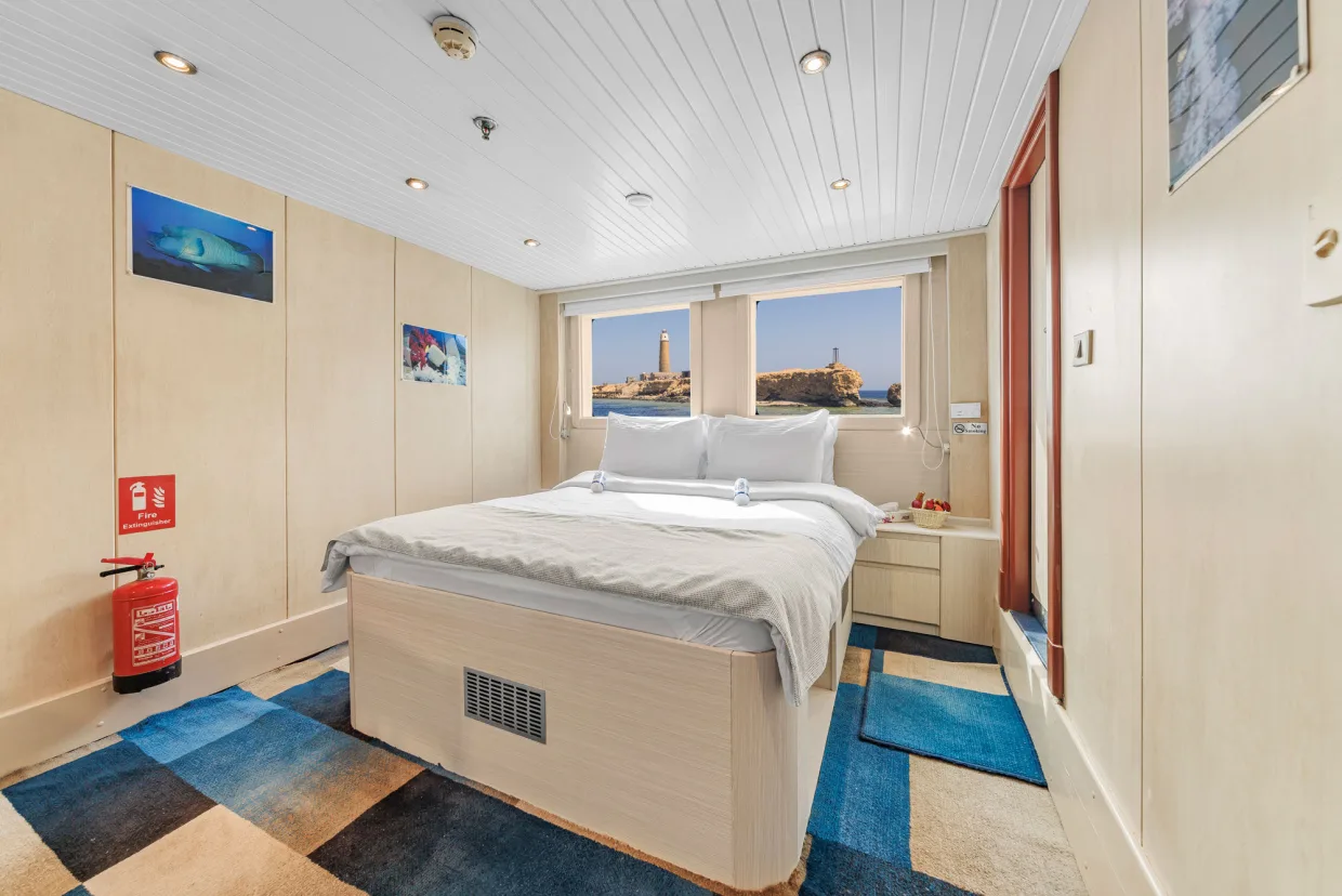 Double Suite on Royal Evolution — bed set centrally with a window at the head