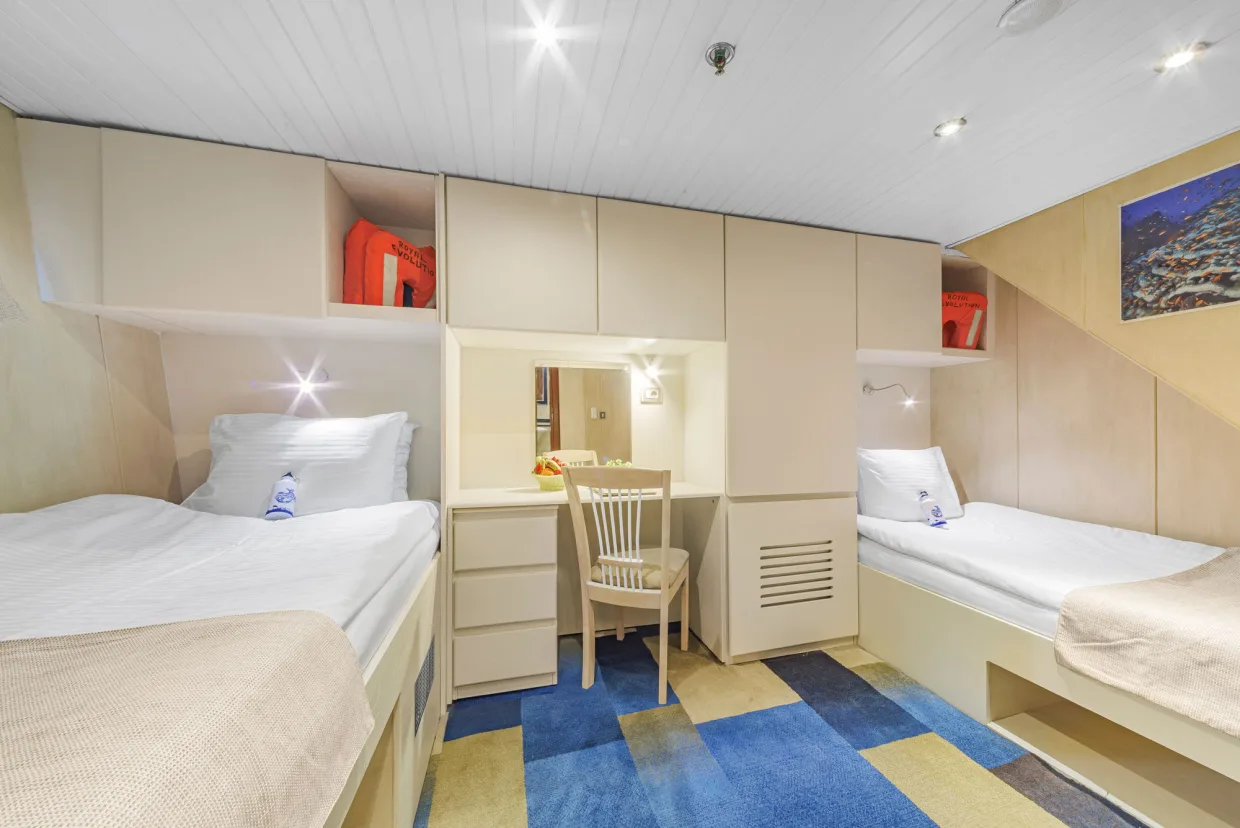 Standard lower-deck cabin on Royal Evolution with two separate beds and a vanity