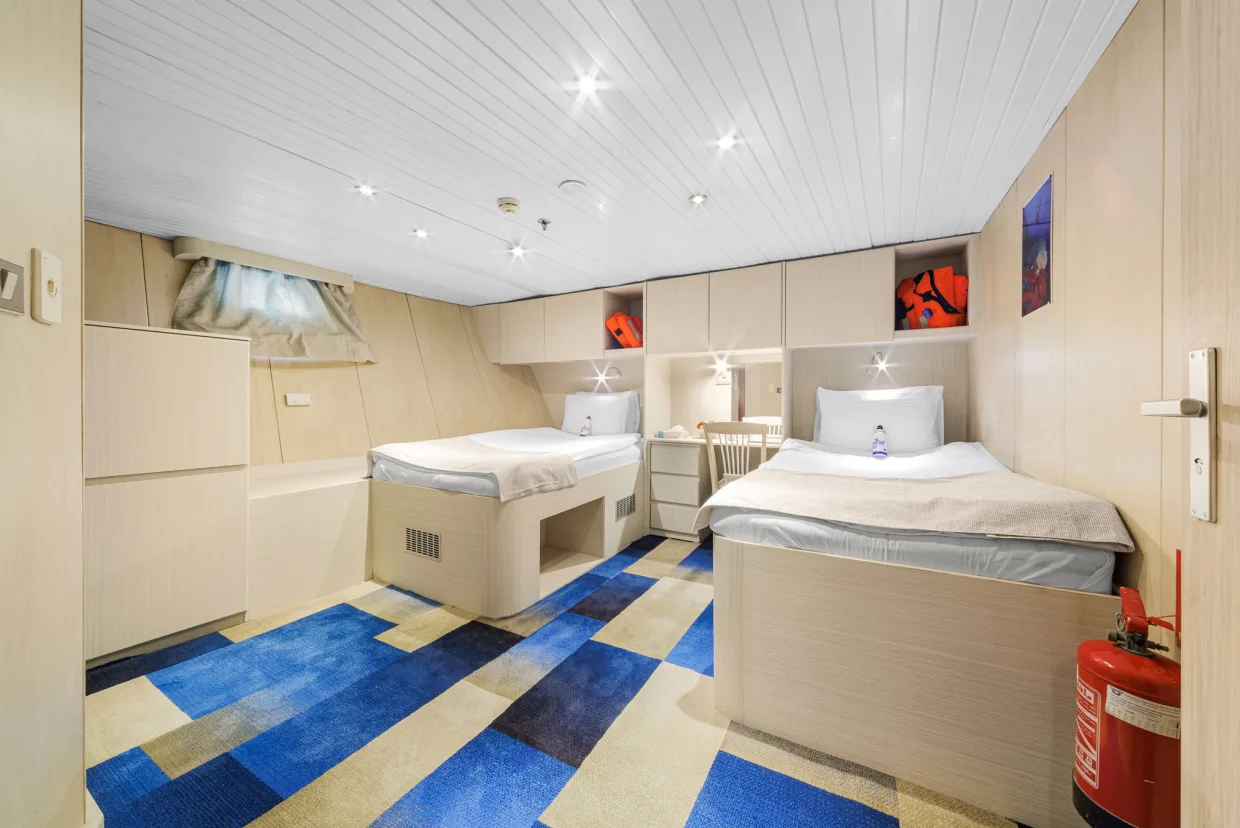 Aft standard cabin on Royal Evolution with a wide walkway between the beds