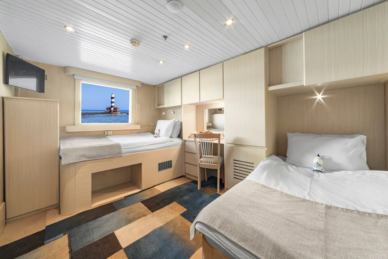 Twin Suite on Royal Evolution — a lighthouse seen from the cabin window
