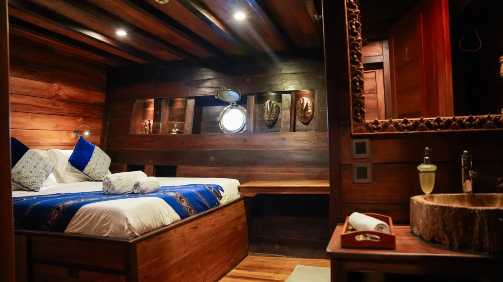 Lit niches above the headboard and blue accents in the cabin