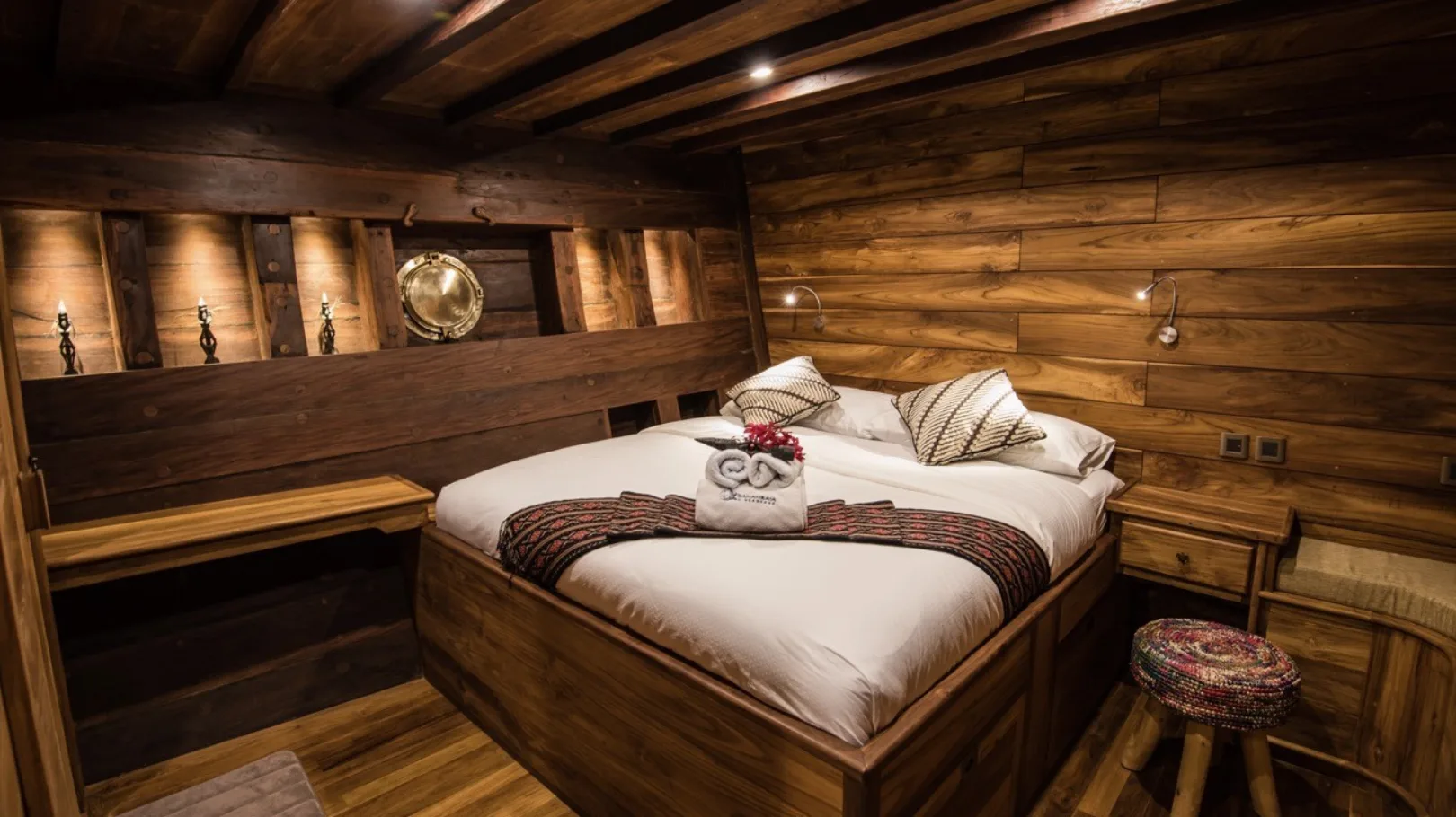 Double cabin with a blue woven runner and patterned cushions