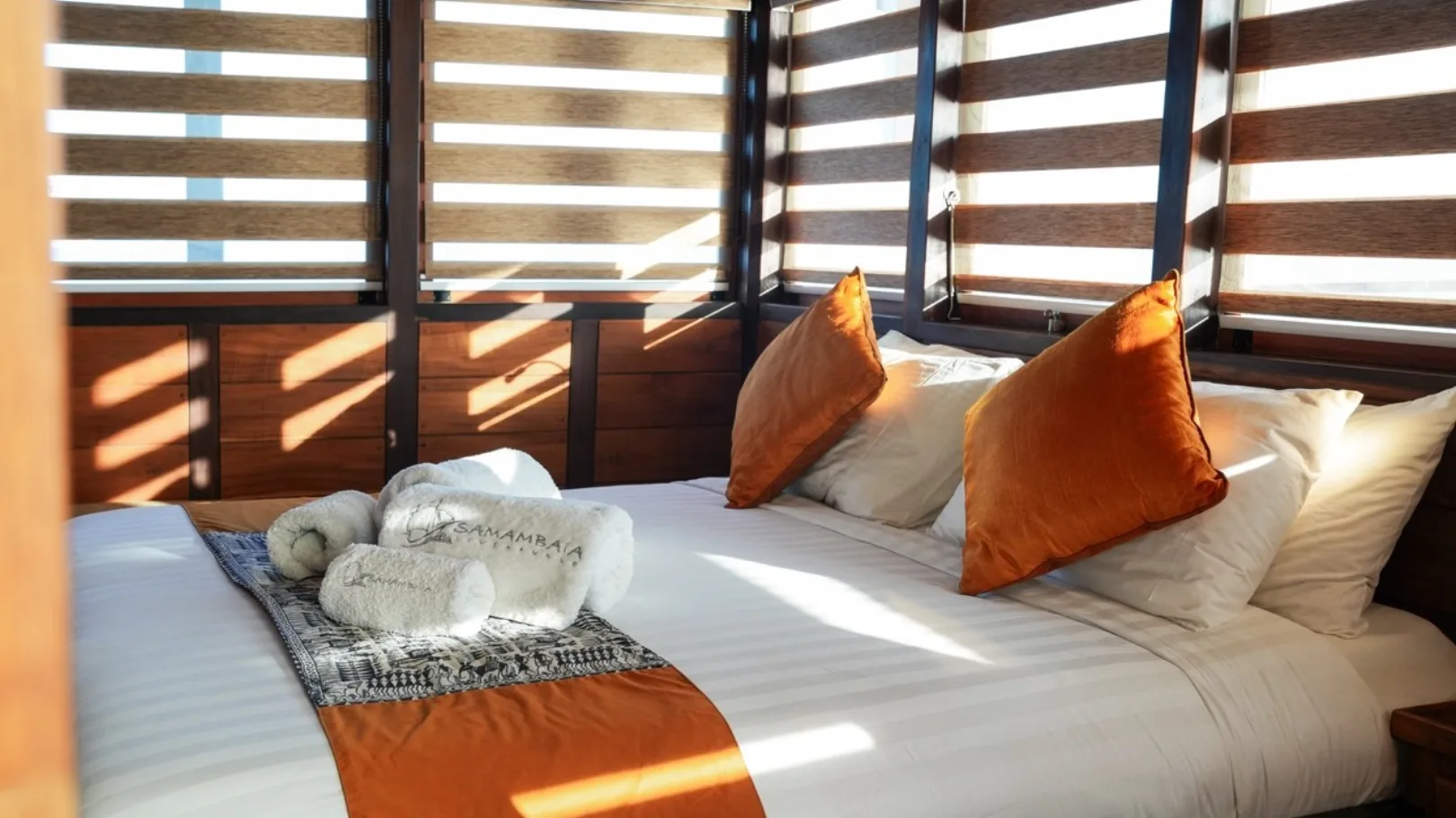 Master cabin aft on the main deck — king-size bed and louvred windows along the wall