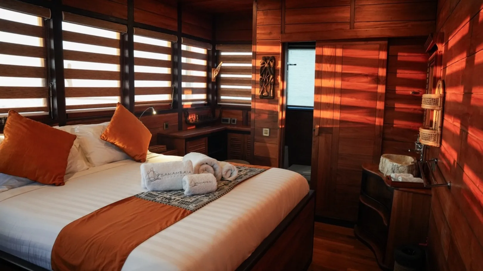Panoramic windows of the master cabin looking out at a volcanic island