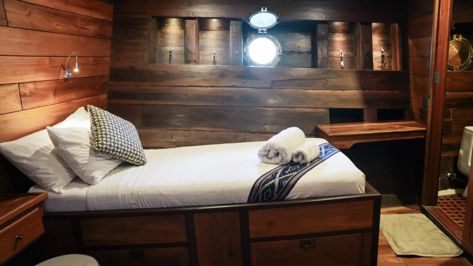 Lower-deck twin cabin with a porthole-shaped light fitting