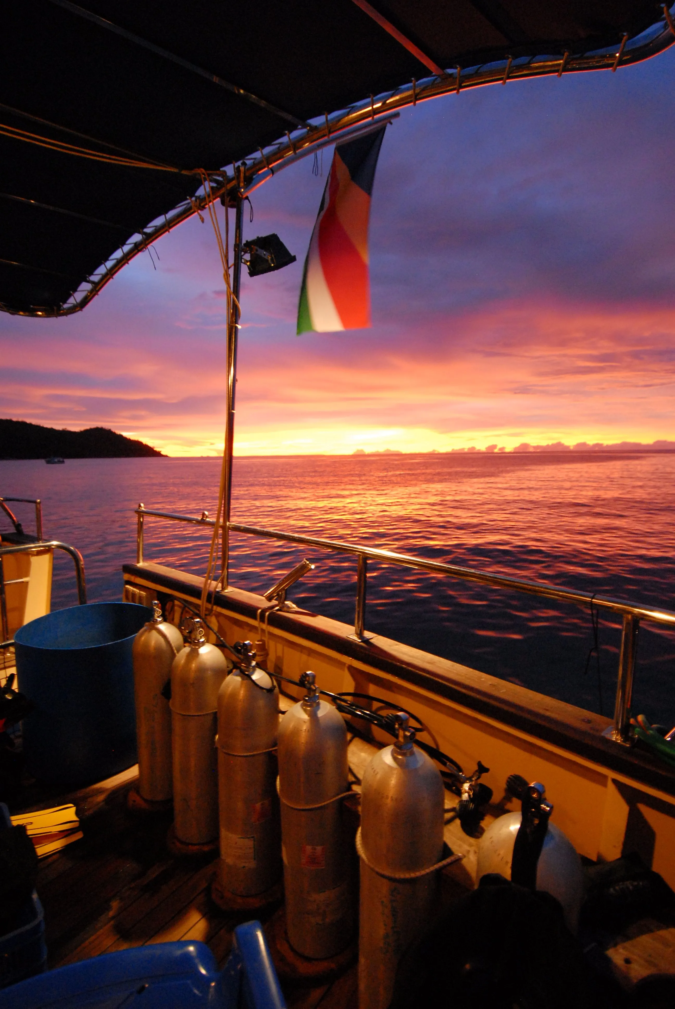 A row of cylinders on deck at sunset