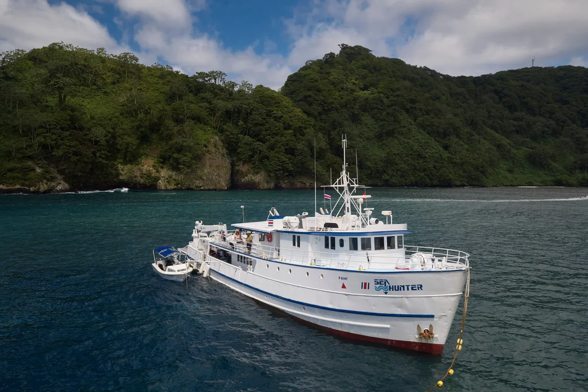 Sea Hunter at anchor below the cliffs of Cocos Island