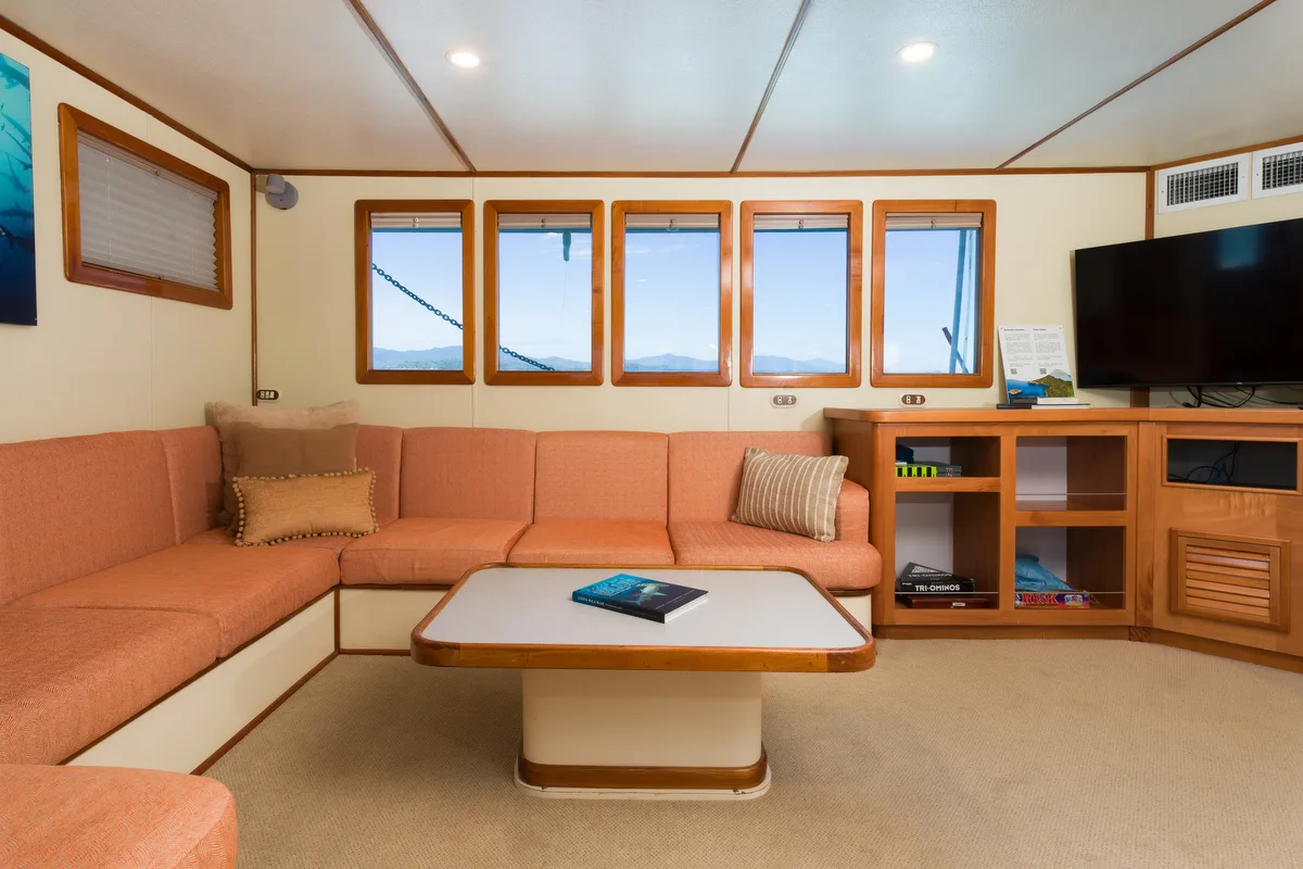 Sea Hunter's saloon — corner sofa and a run of windows along the side