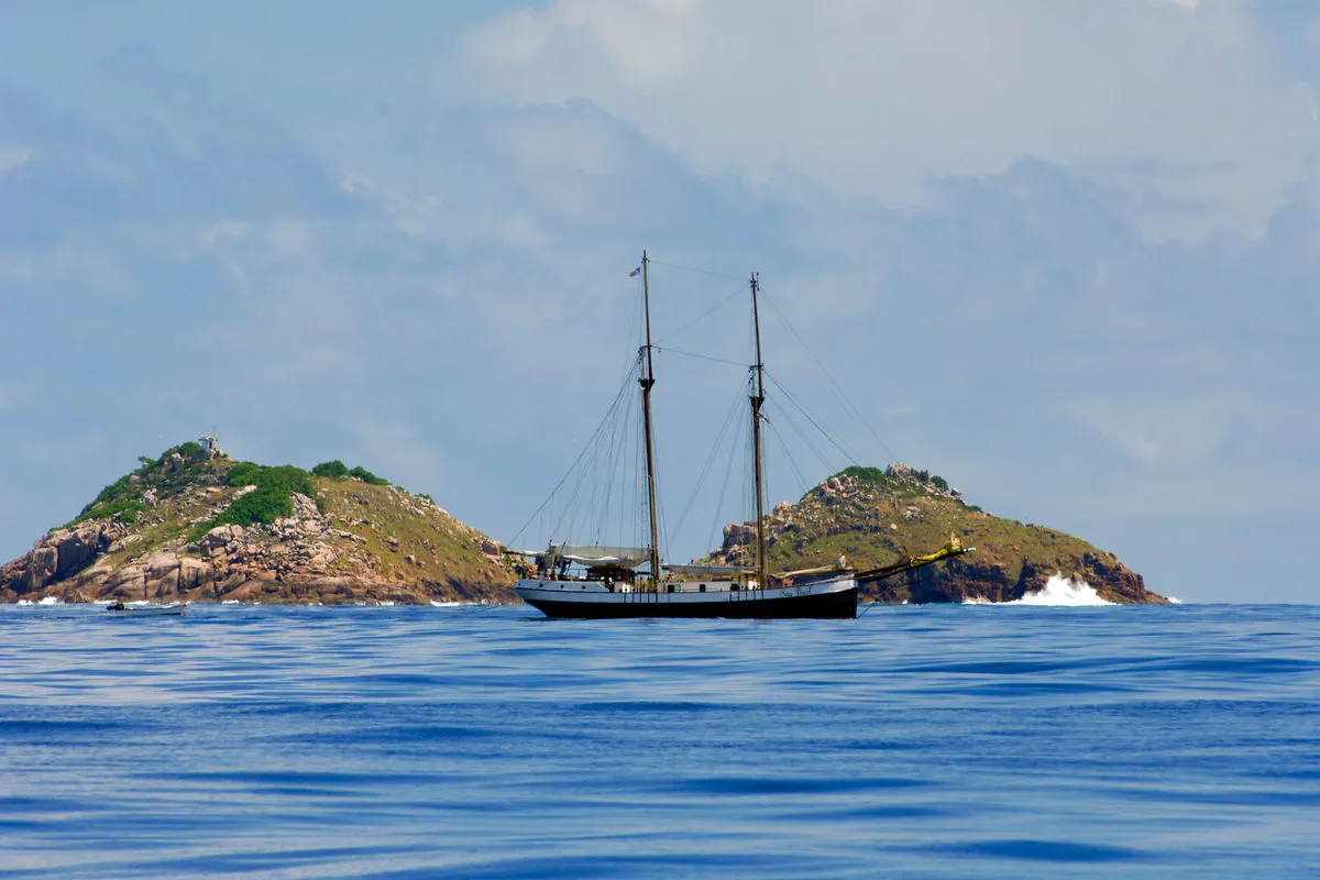 The schooner beside a rocky islet in open water