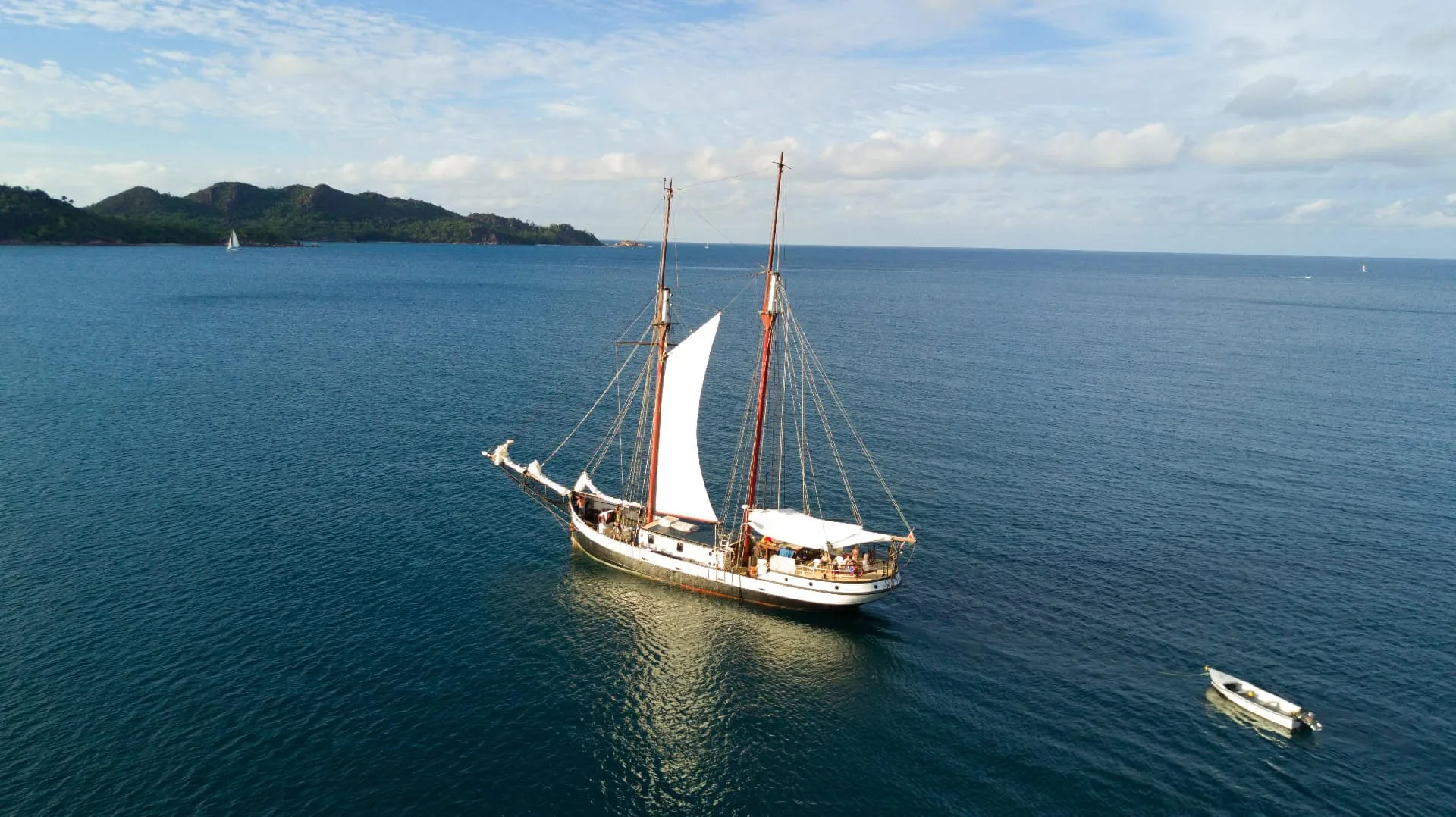 Sea Pearl at anchor as a boatload of guests heads for the beach
