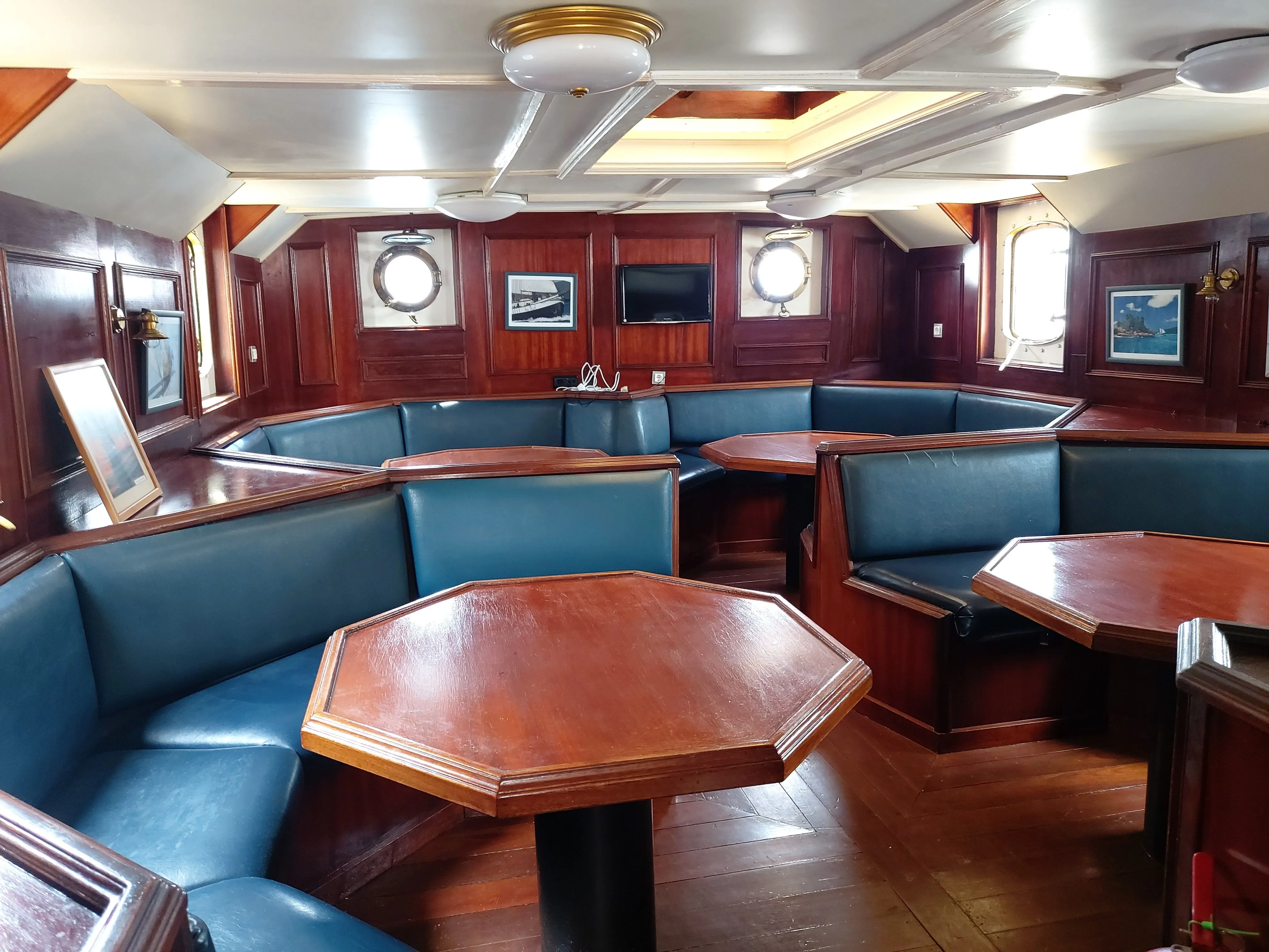 The air-conditioned saloon of Sea Pearl with leather banquettes and timber tables