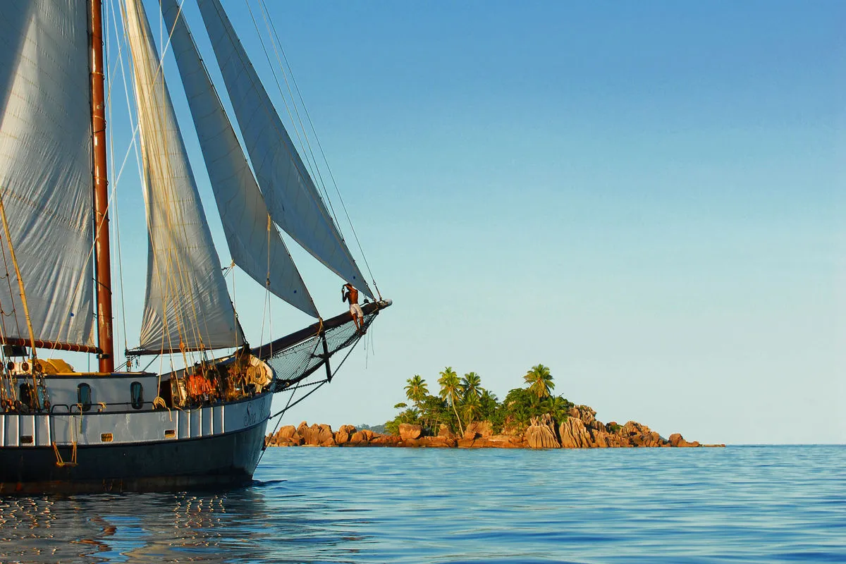 The bowsprit of Sea Pearl and a palm-covered islet beyond