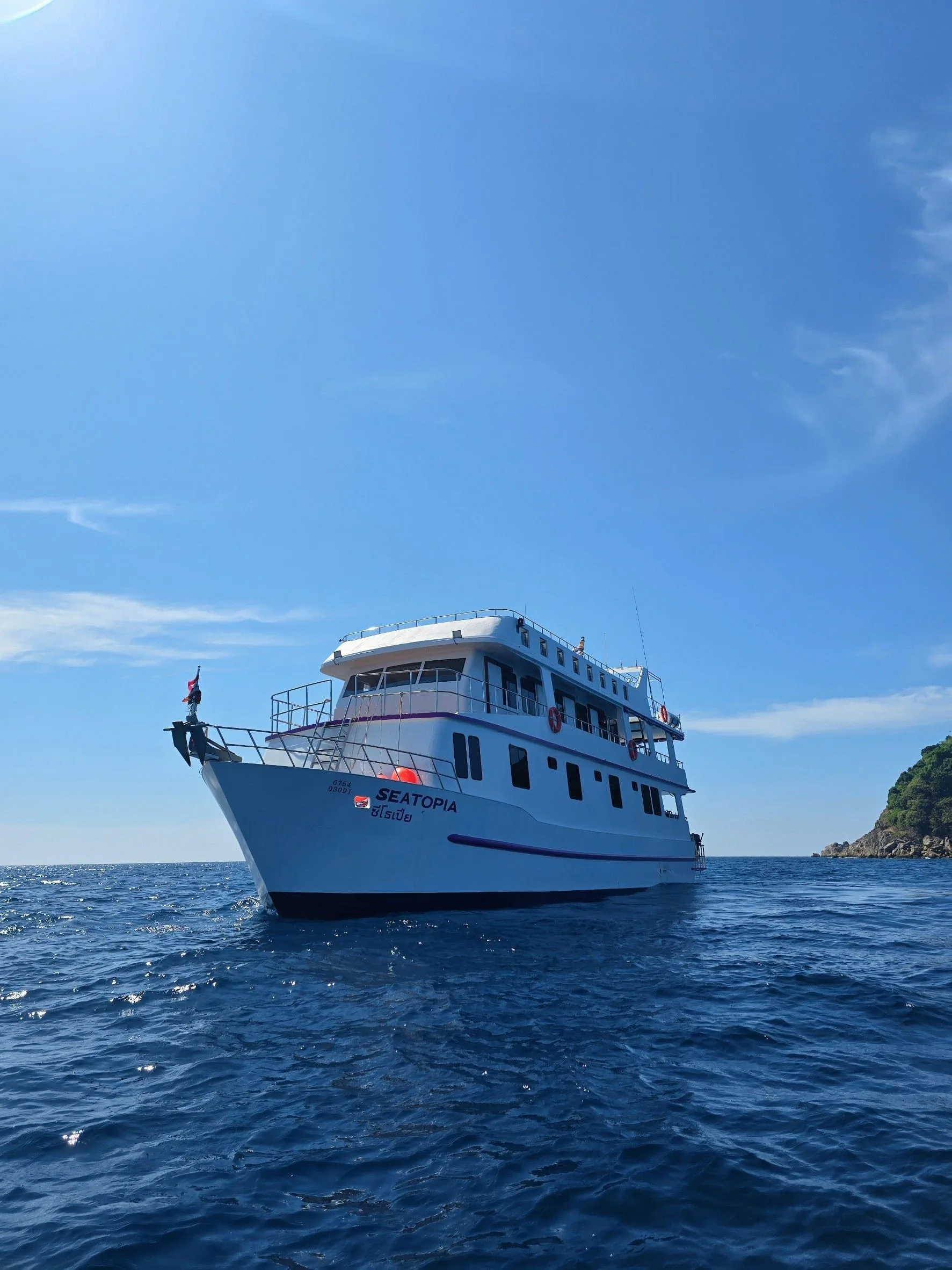 Seatopia at anchor in the Andaman Sea, her name on the white hull