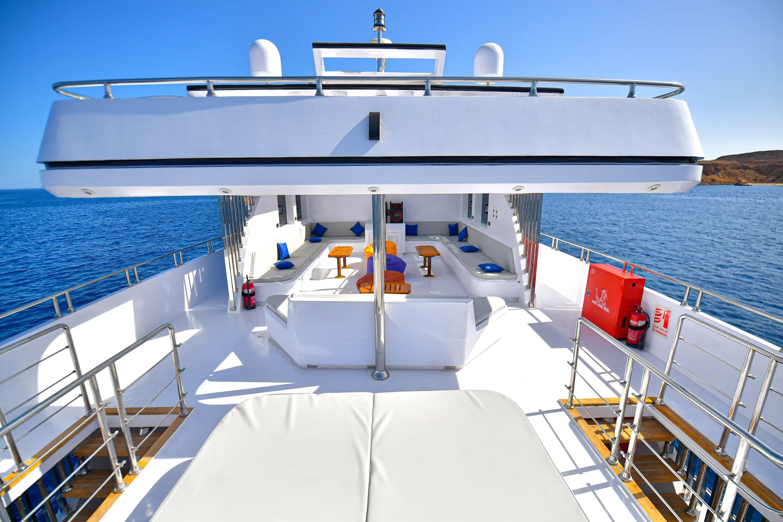Upper sun deck with mattresses and lounge seating