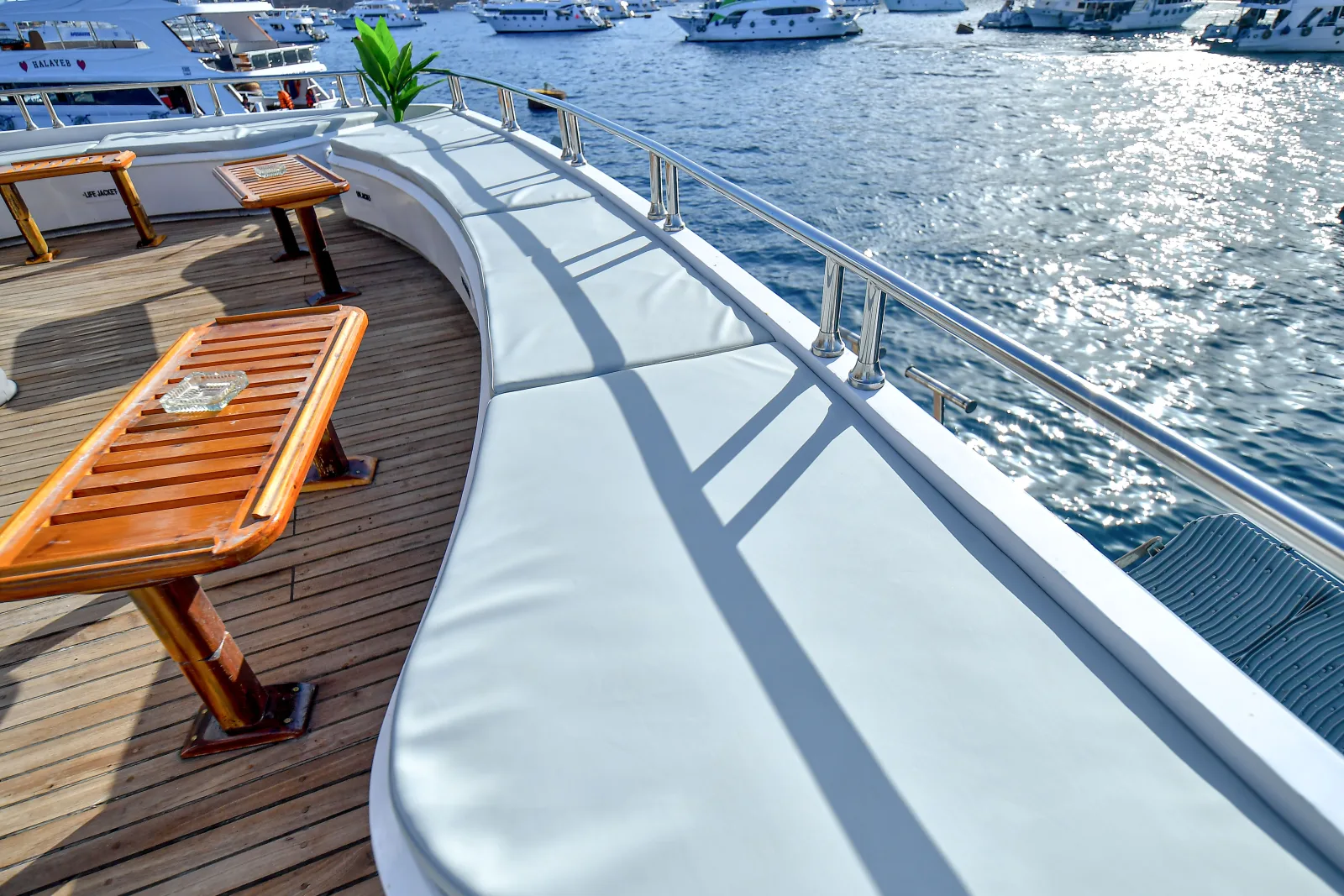 Cushioned bench along the rail with wooden tables