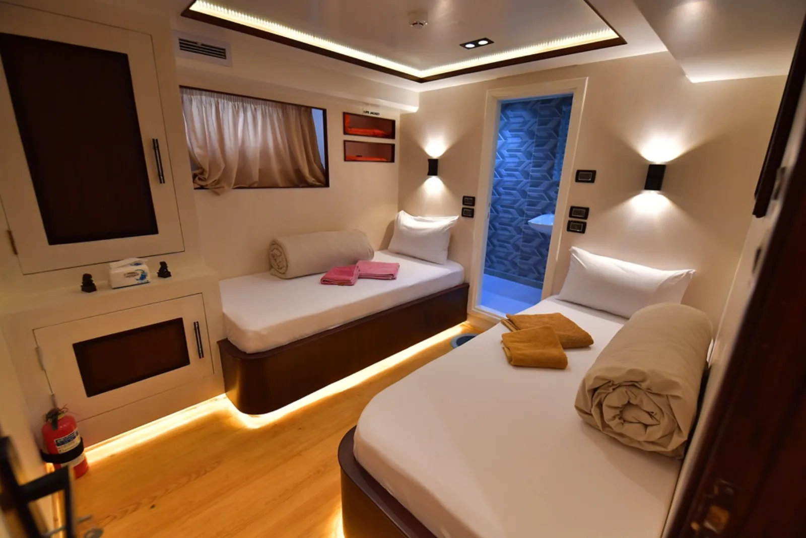 Lower deck twin cabin on South Moon 1 — two beds, curtained window and the bathroom door
