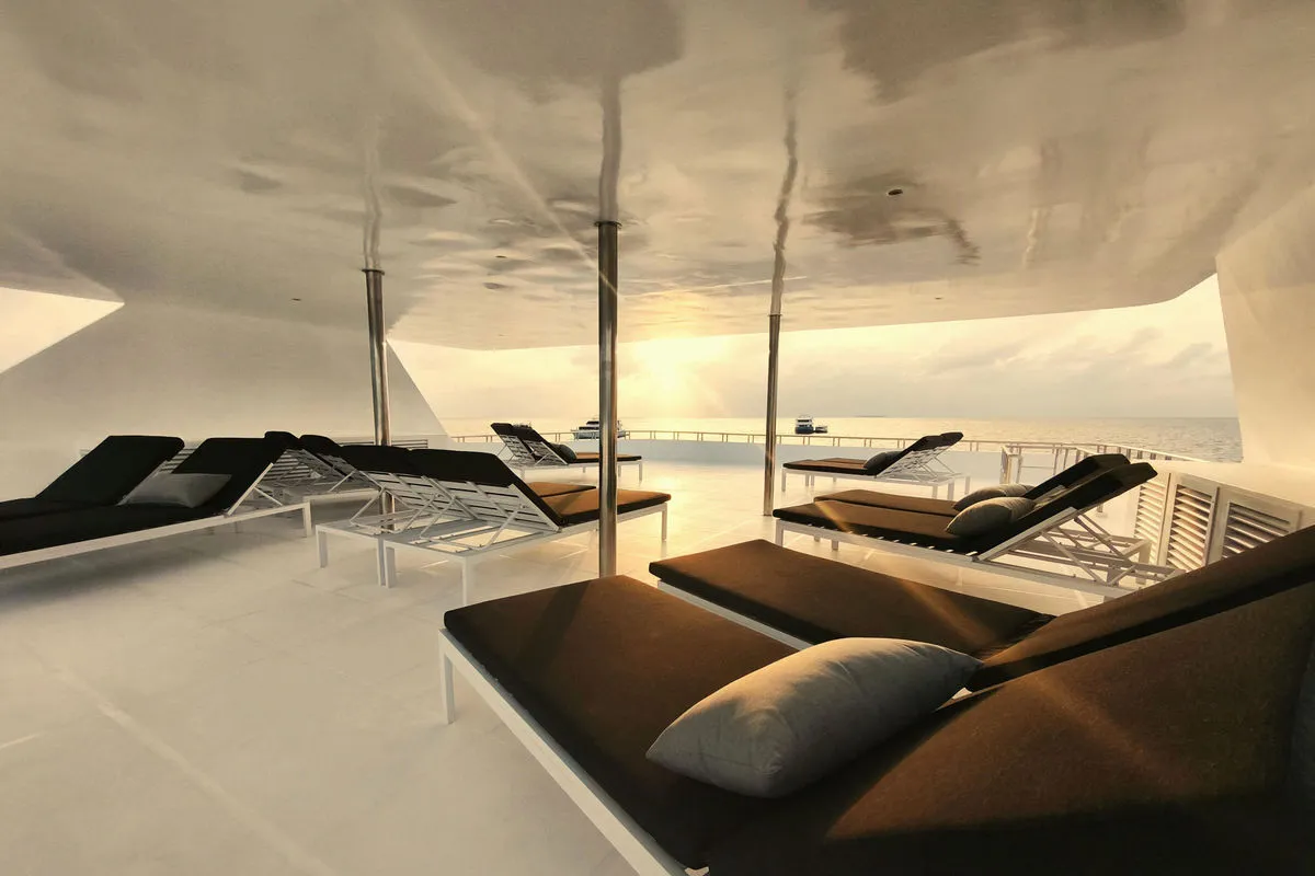 Sun deck of Spirit of Maldives with loungers at sunset