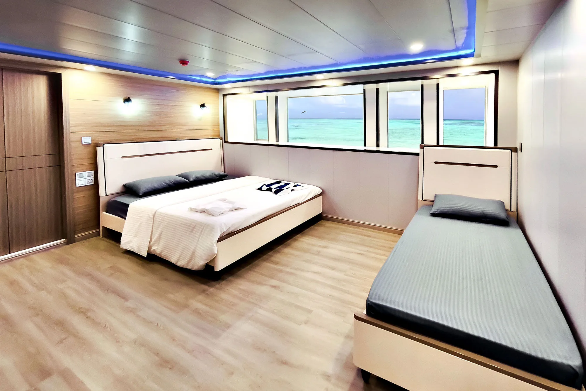 Main deck suite on Spirit of Maldives — king-size bed by the windows