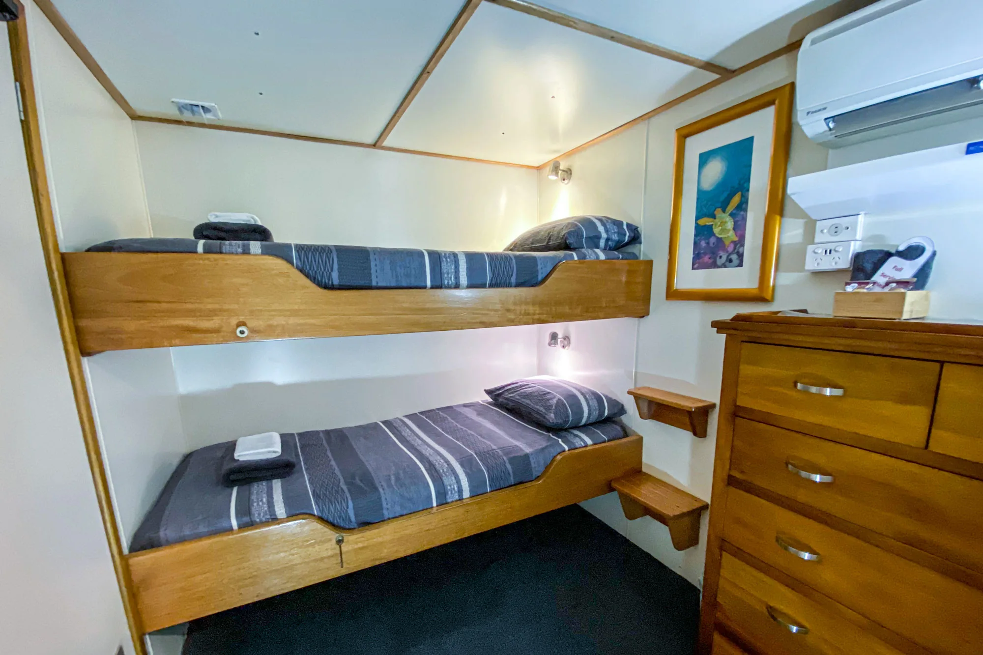 Spoilsport club cabin — bunk beds and a timber chest of drawers