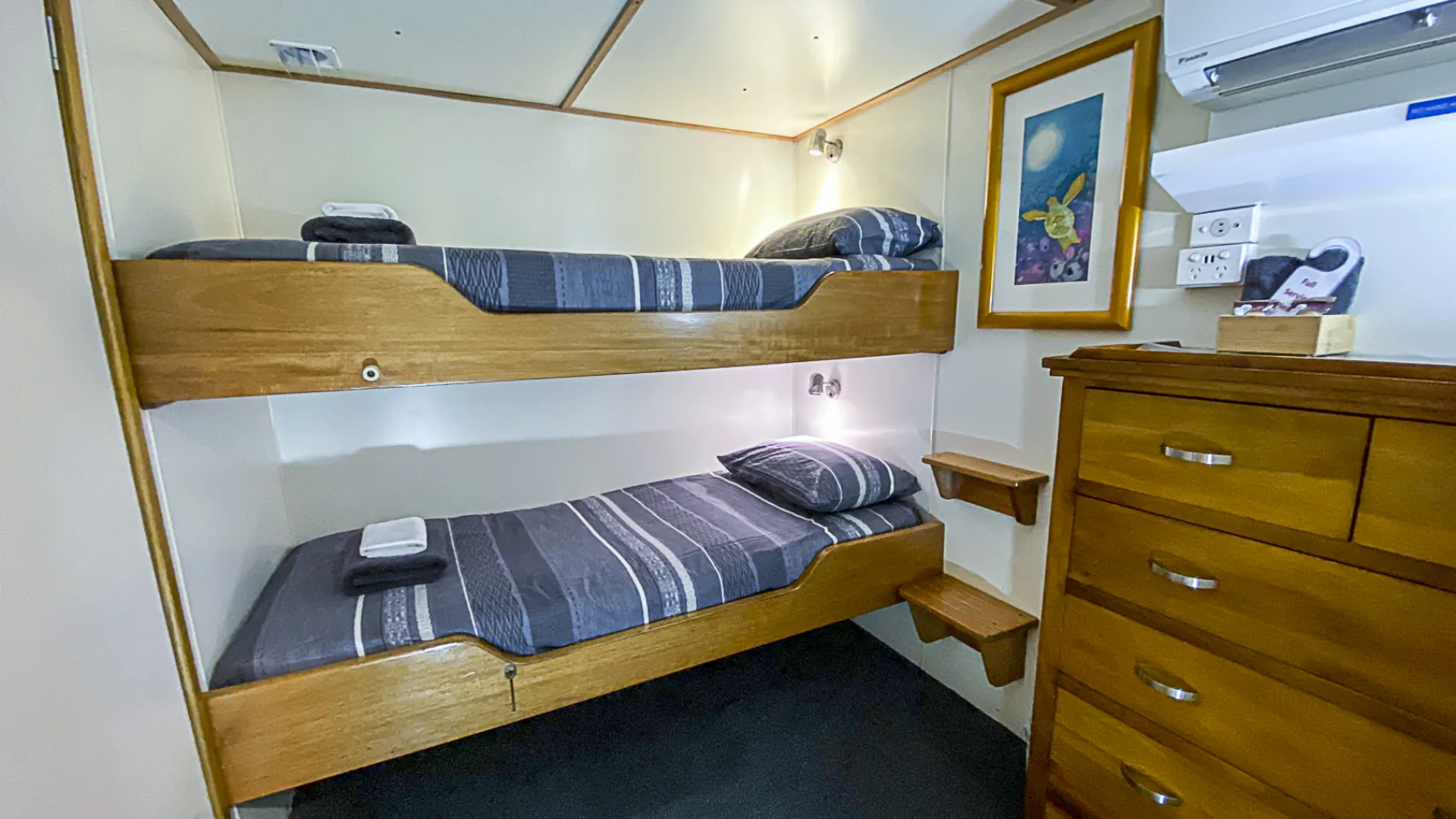 Club cabin — lower bunk with towels, reading light and air conditioning