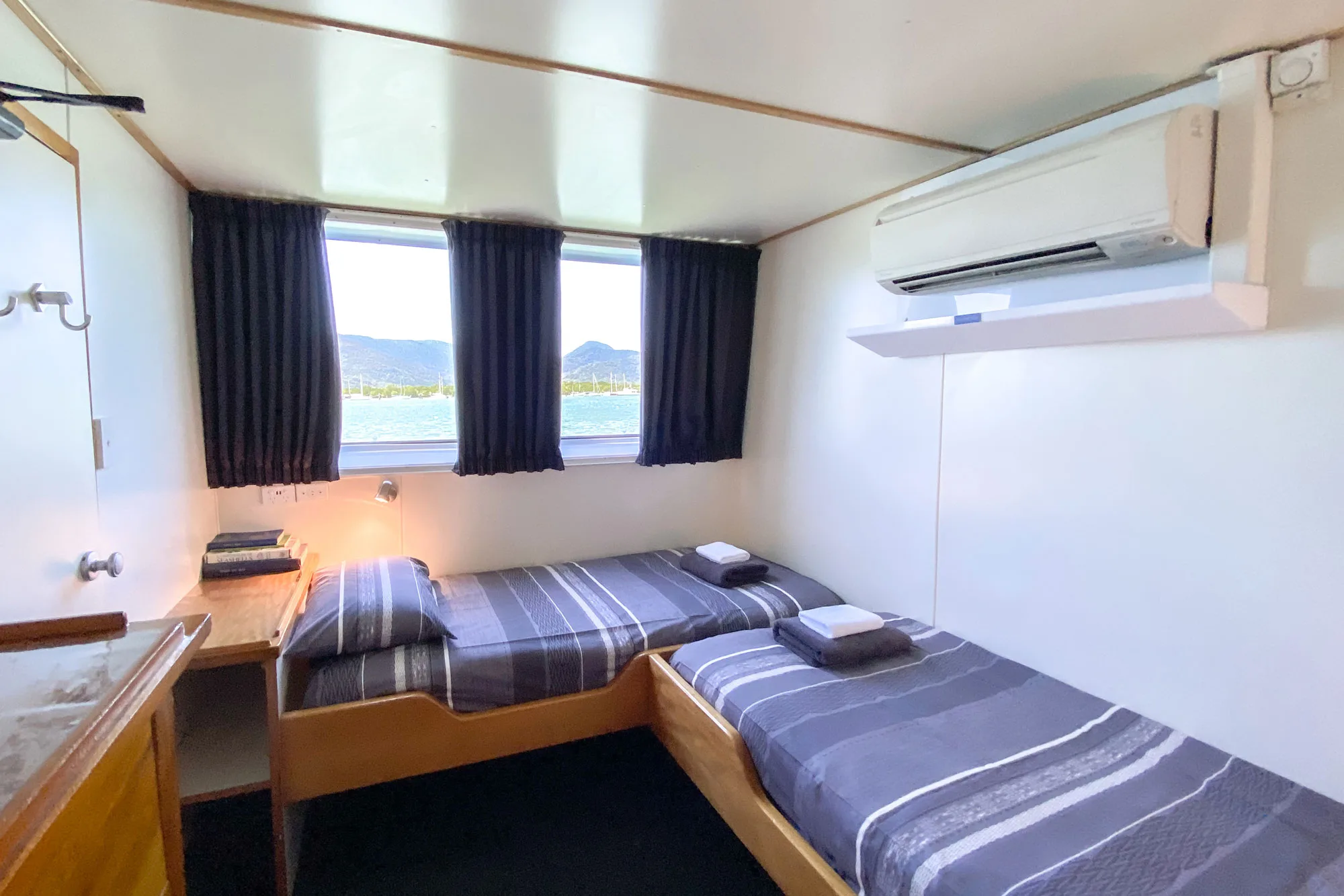 Spoilsport standard cabin — two single beds beside a panoramic window