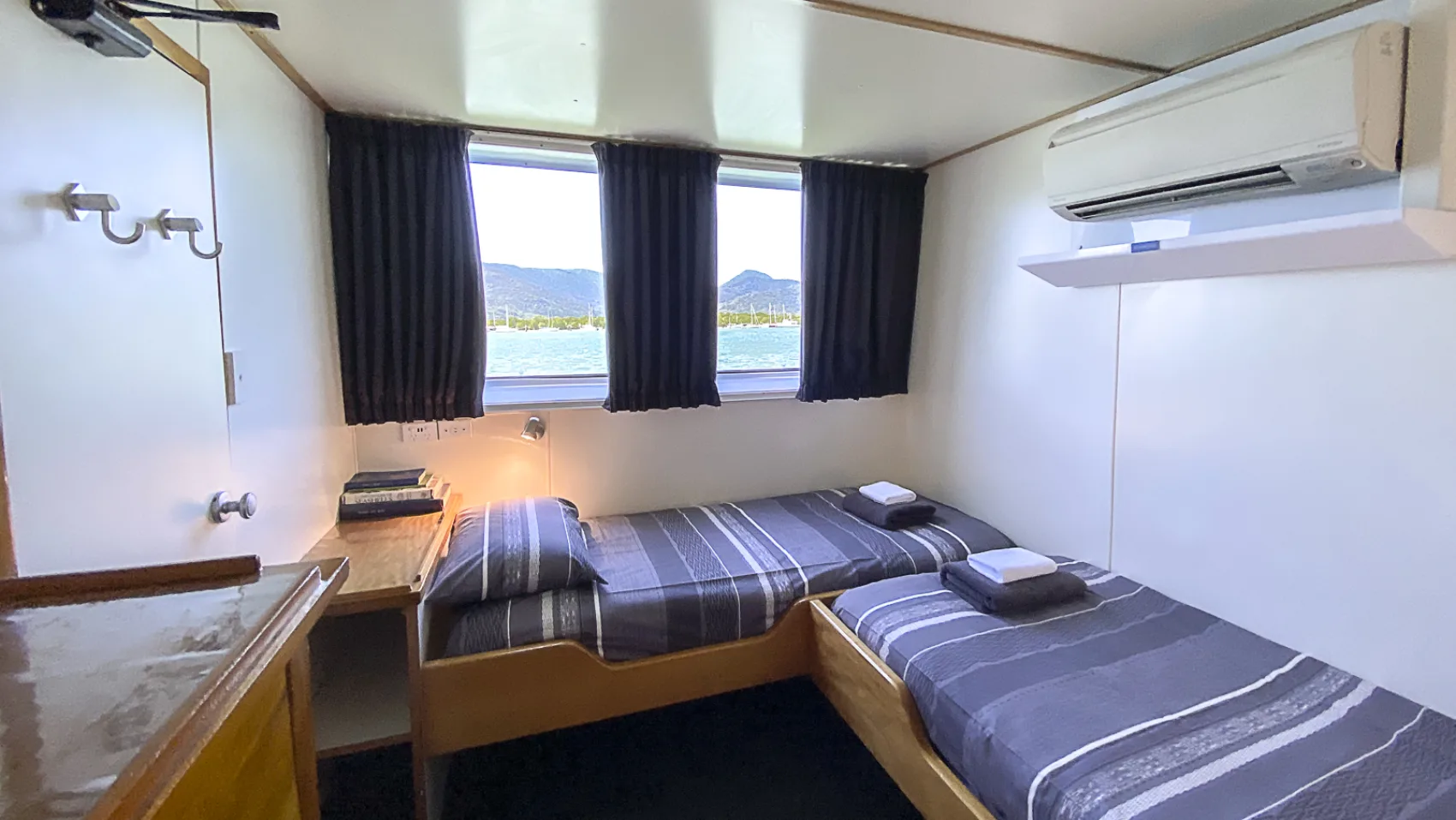 Standard cabin — desk, mirror and air conditioning above the beds