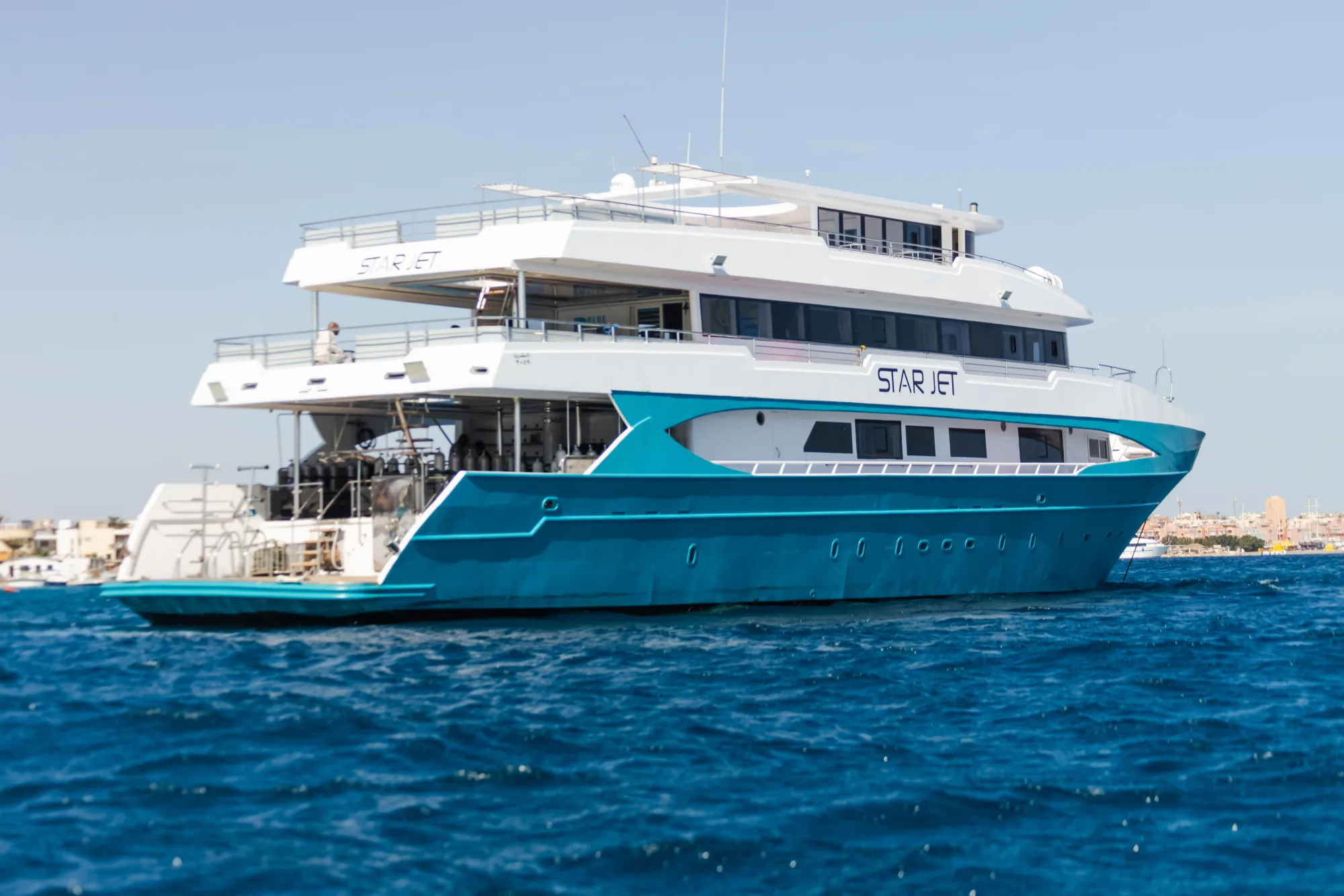 Star Jet на якоре у Хургады — бирюзовый корпус, белая надстройка и имя судна на борту