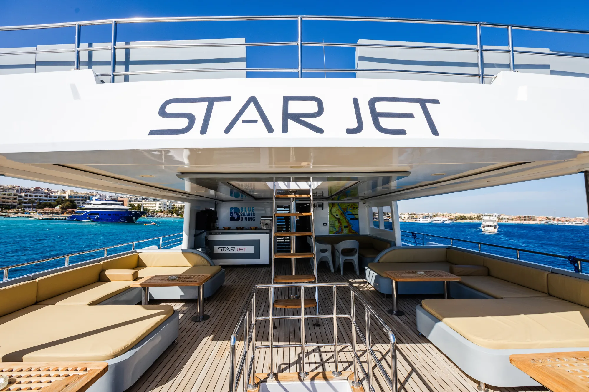 Кормовая зона отдыха Star Jet с диванами и трапом, имя судна на переборке