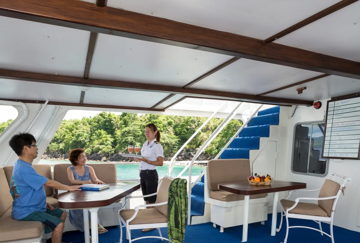 Shaded aft deck of Thailand Aggressor with tables