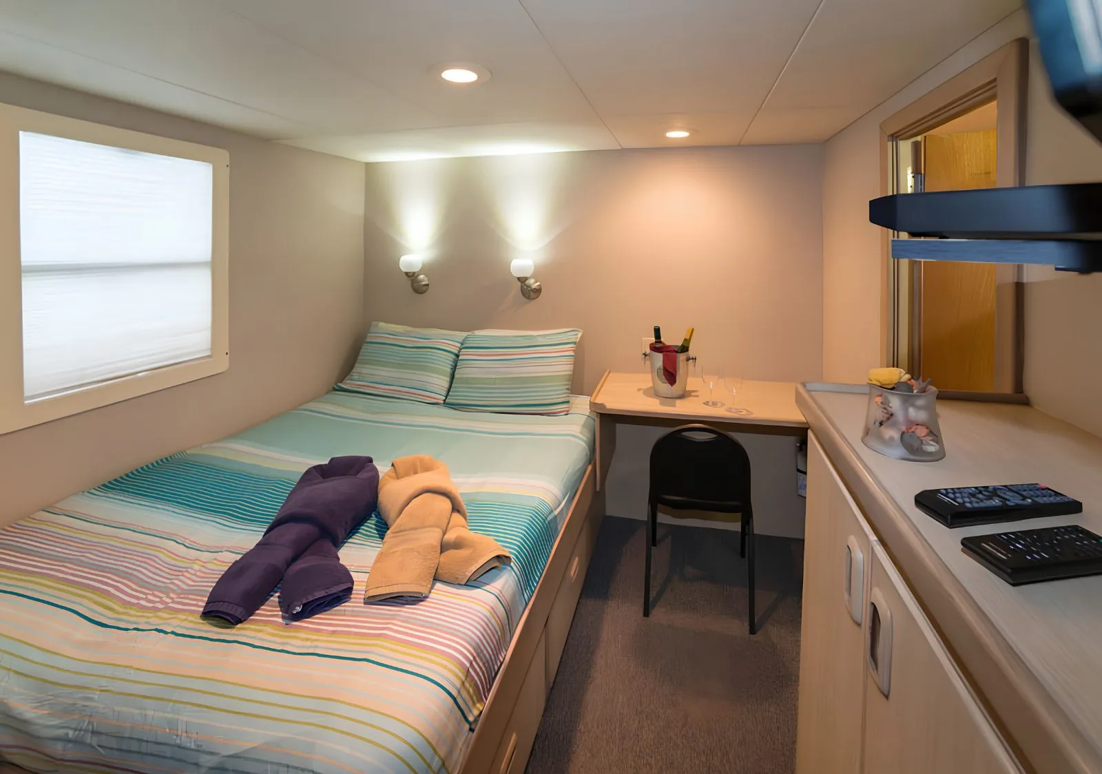 Main deck stateroom on Turks & Caicos Explorer II — queen bed and writing desk