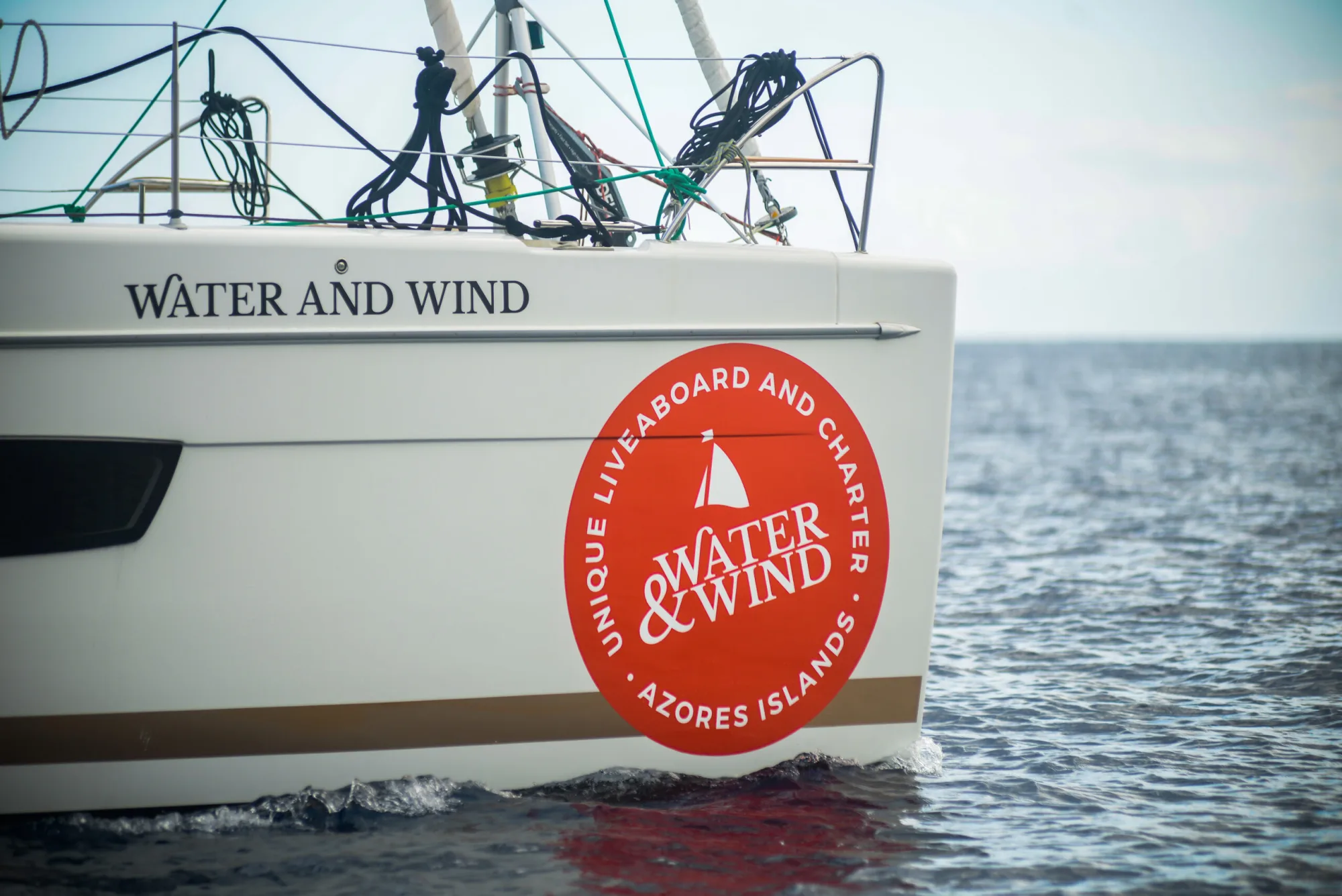 Надпись Water and Wind и красная эмблема на борту в море