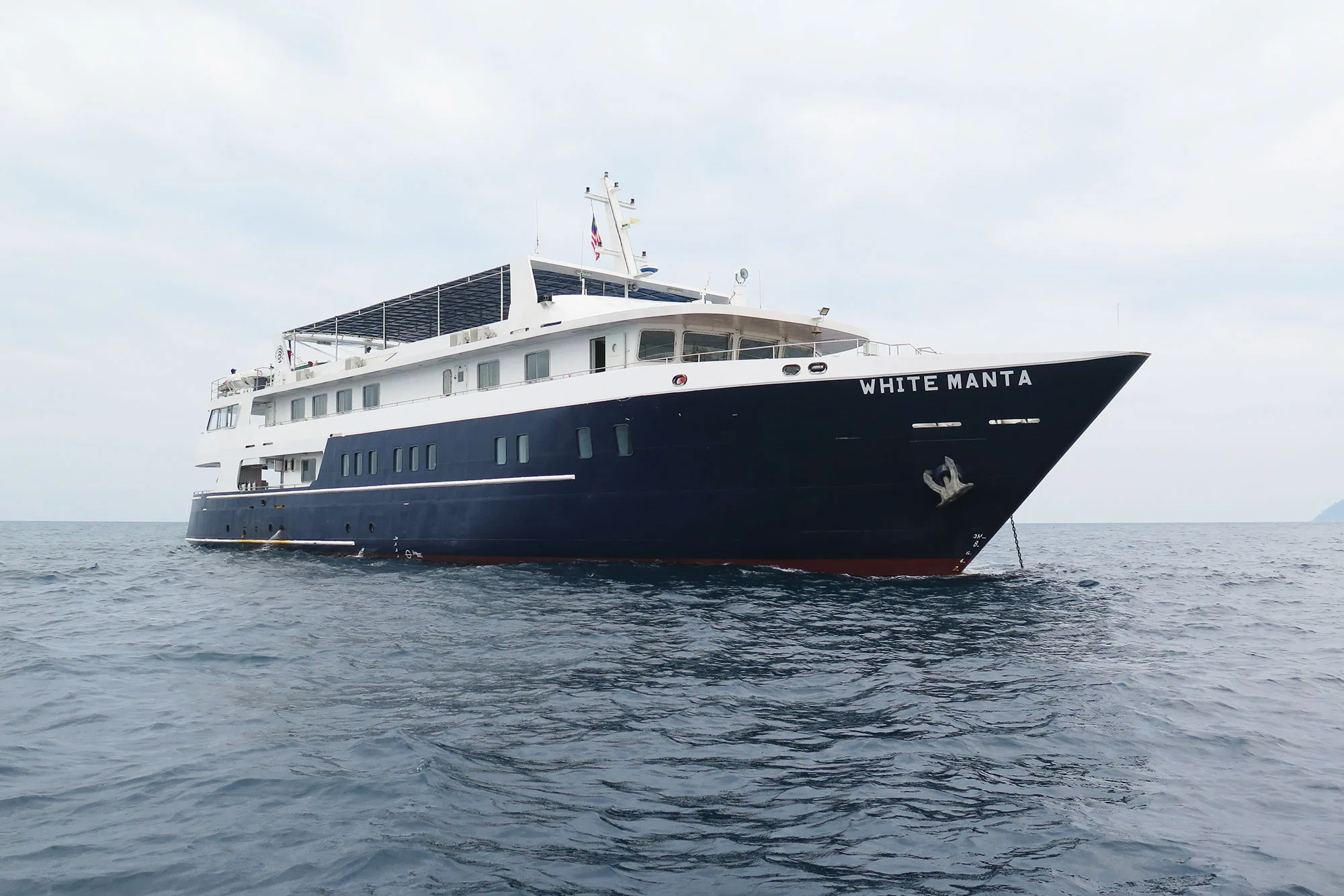 White Manta на ходу с правого борта, за кормой берег Индонезии