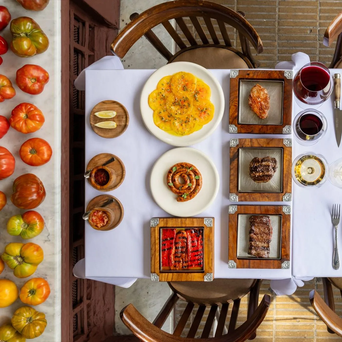 Стол в Don Julio сверху — стейки, колбаски, соусы, вино и томаты