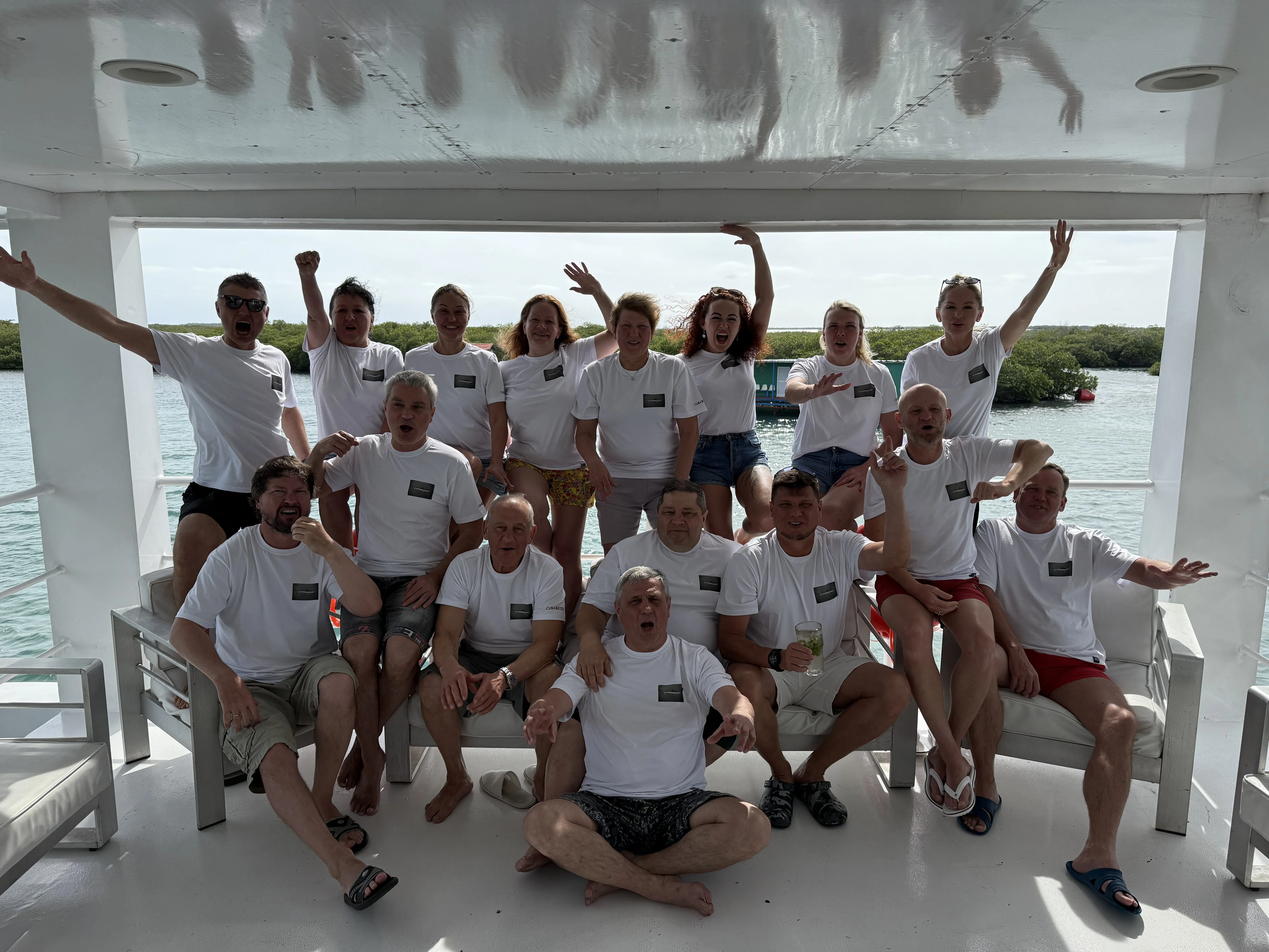 Групповое фото в майках Tour Leader Club — на палубе, на фоне мангровых островов