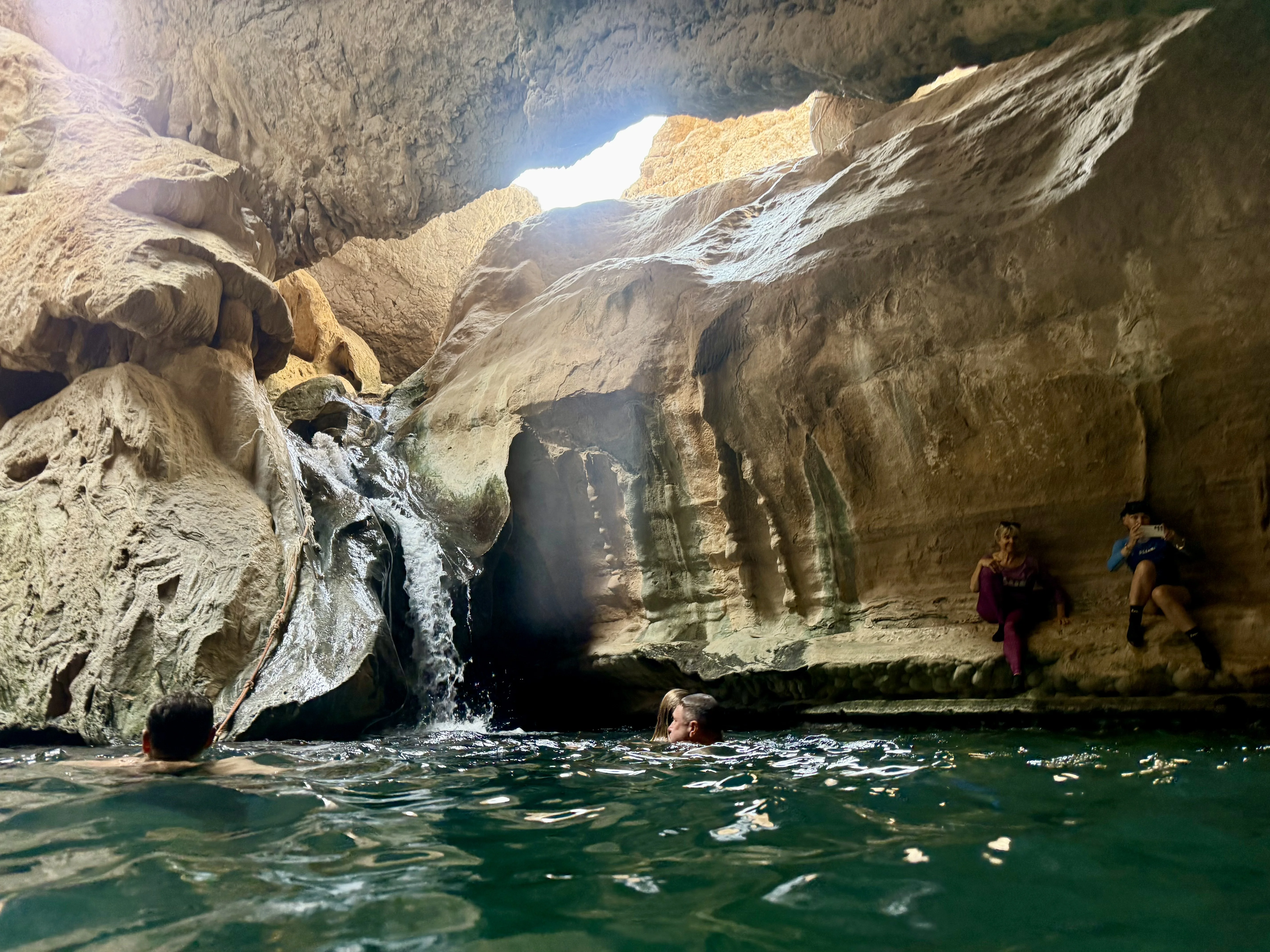 Грот — водопад падает из отверстия в потолке, люди плавают внизу