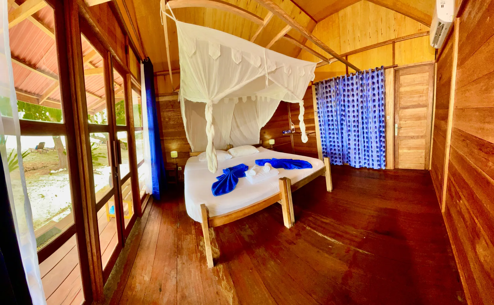 Кровать под москитной сеткой в деревянном Raja Cottage