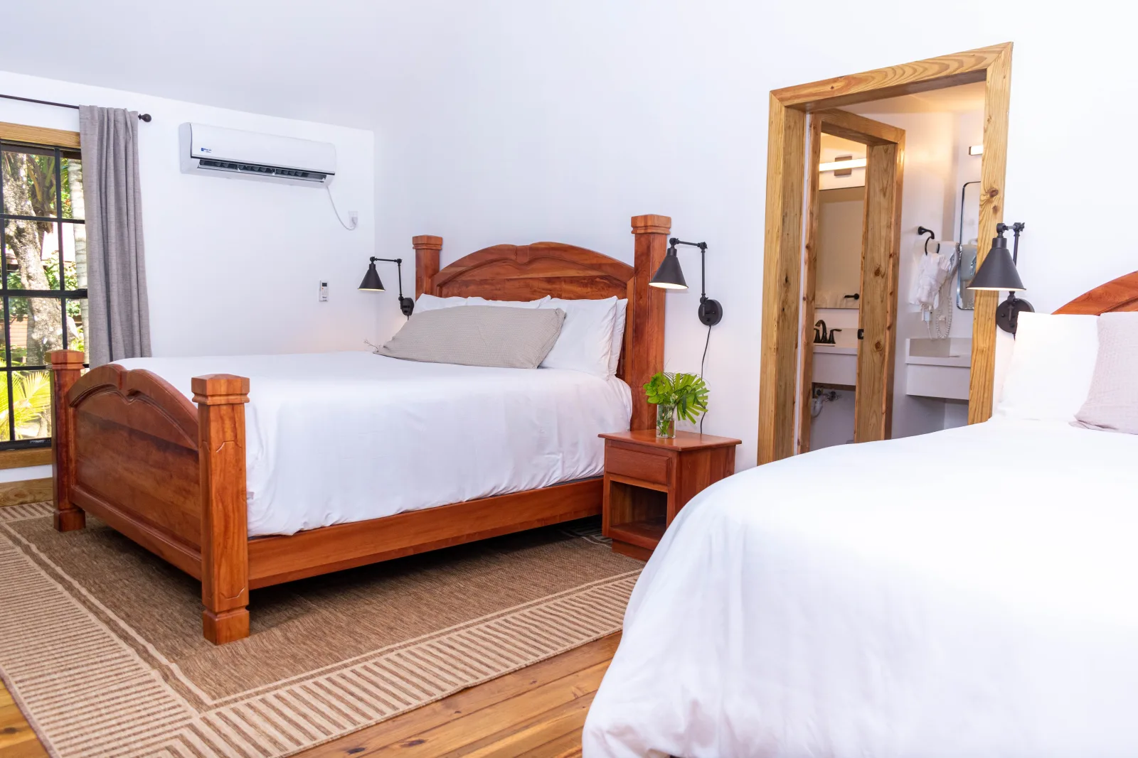 Two beds with wooden headboards and an air conditioner