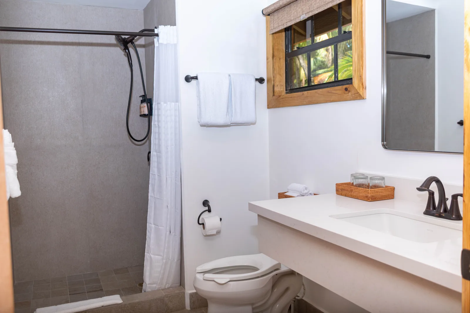 Bathroom with a shower and a wooden-framed mirror