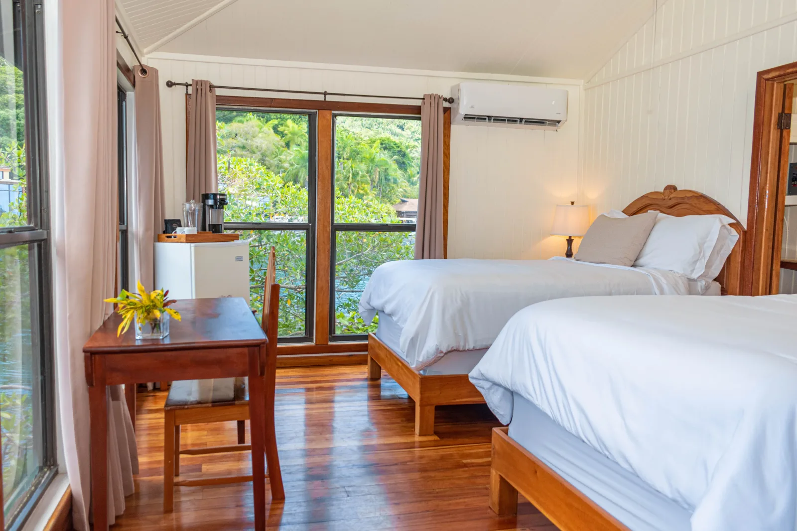 Two beds and a desk by the window