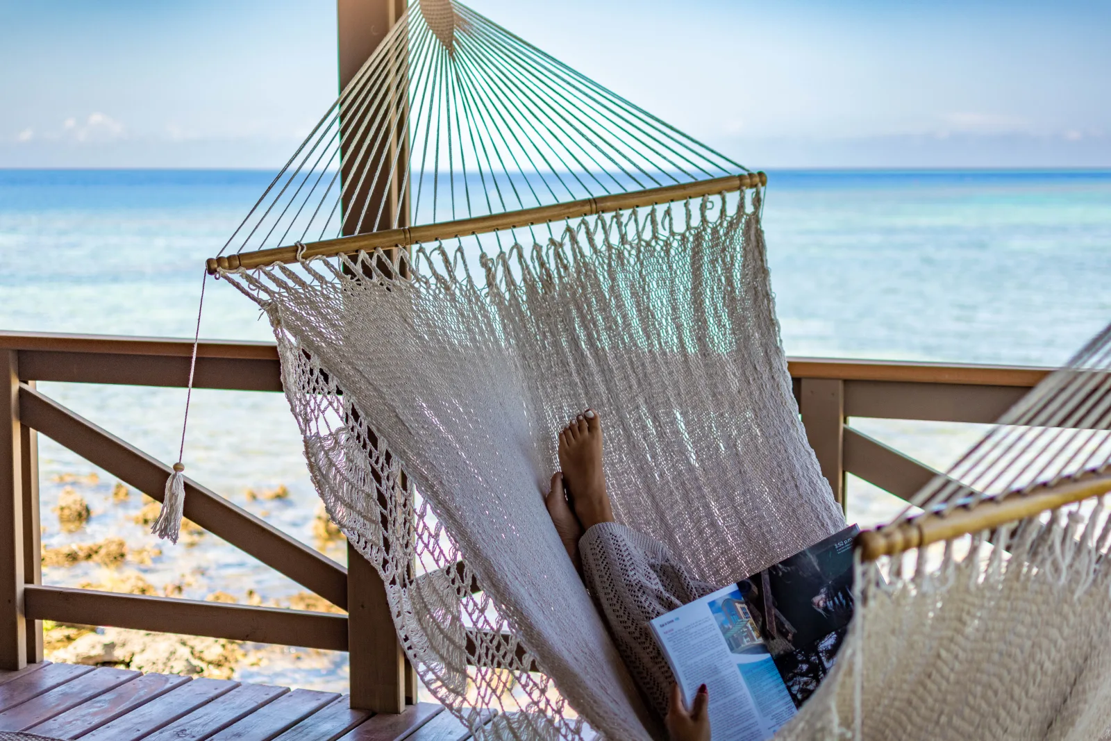 Hammock on the deck with turquoise sea beyond the rail